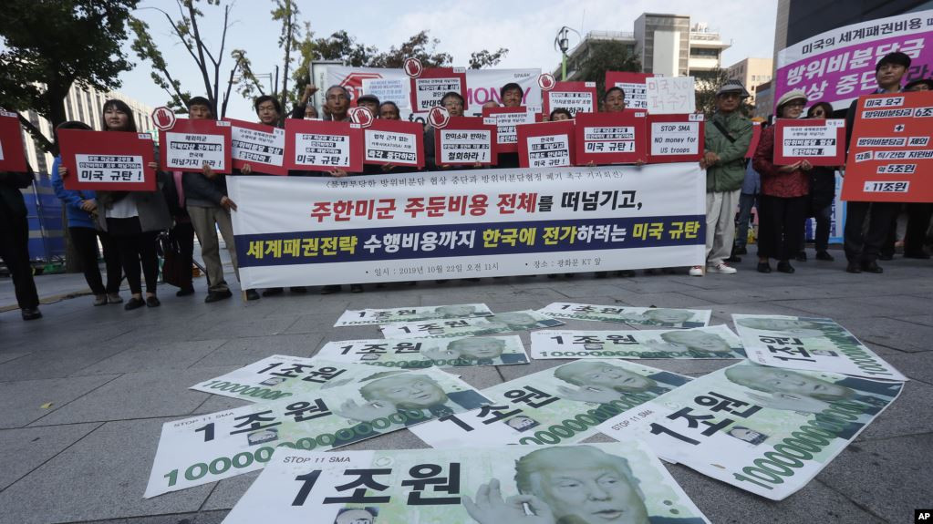 Các tờ tiền giả với hình ảnh Tổng thống Mỹ Donald Trump được bày trên đường trong khi những người biểu tình tụ tập gần Sứ quán Mỹ ở Seoul để phản đối yêu cầu của Mỹ đòi Seoul tăng chi để binh lính Mỹ đồn trú ở đây. Ảnh: AP