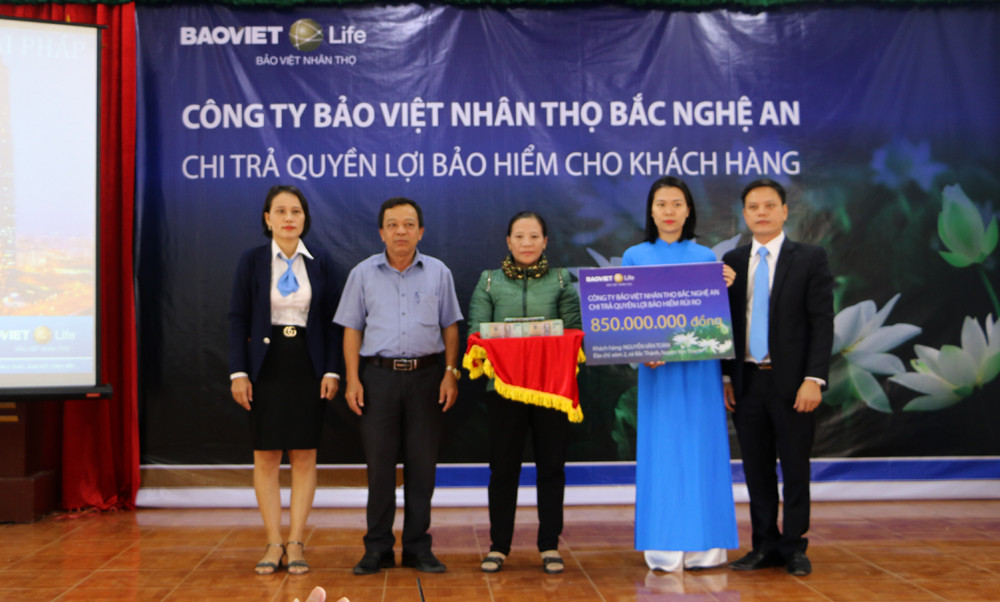 Đại diện Công ty Bảo Việt Nhân thọ Bắc Nghệ An trao số tiền 850 triệu đồng cho gia đình khách hàng. Ảnh: Nguyễn Hải