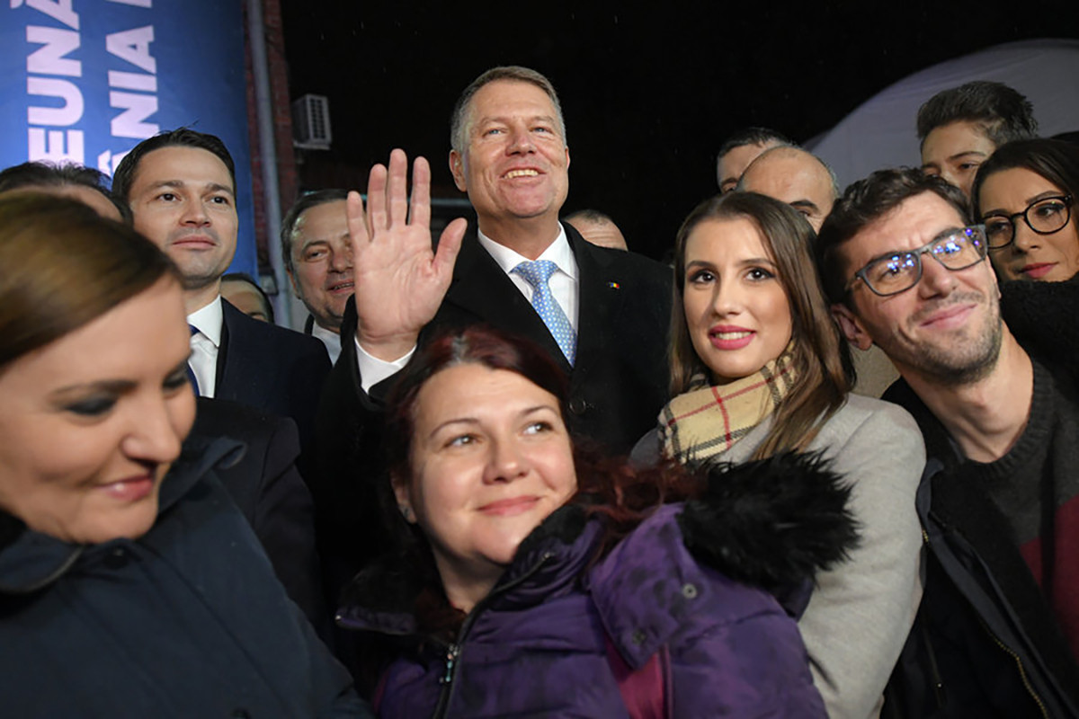 Ông Iohannis chụp ảnh cùng đội ngũ truyền thông sau khi bỏ phiếu tại Bucharest hôm 24-11. Ảnh: AP