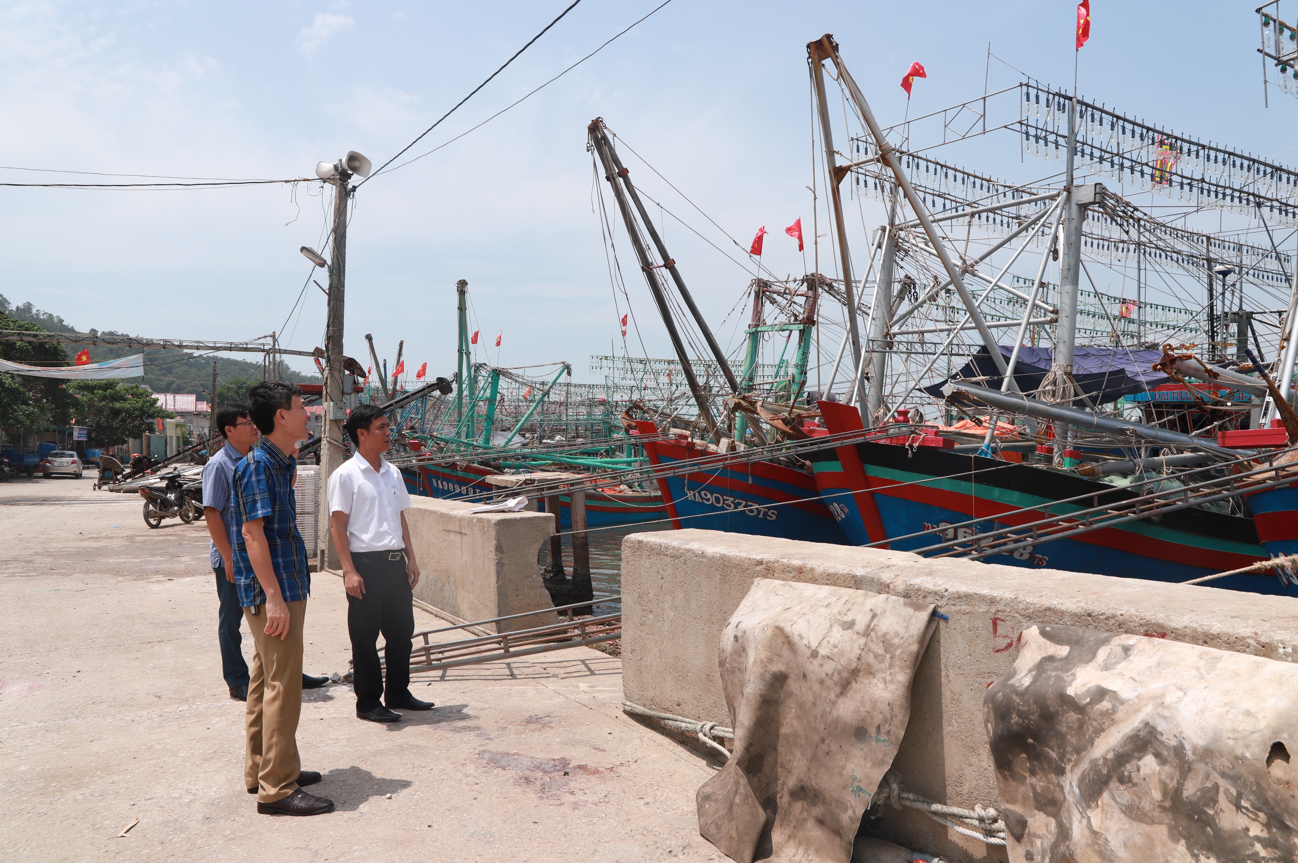 Cán bộ Ban Tổ chức Thị ủy Hoàng Mai (ngoài cùng) trao đổi với cán bộ xã Quỳnh Lập về công tác phát triển đảng viên là ngư dân. Ảnh: Thành Duy