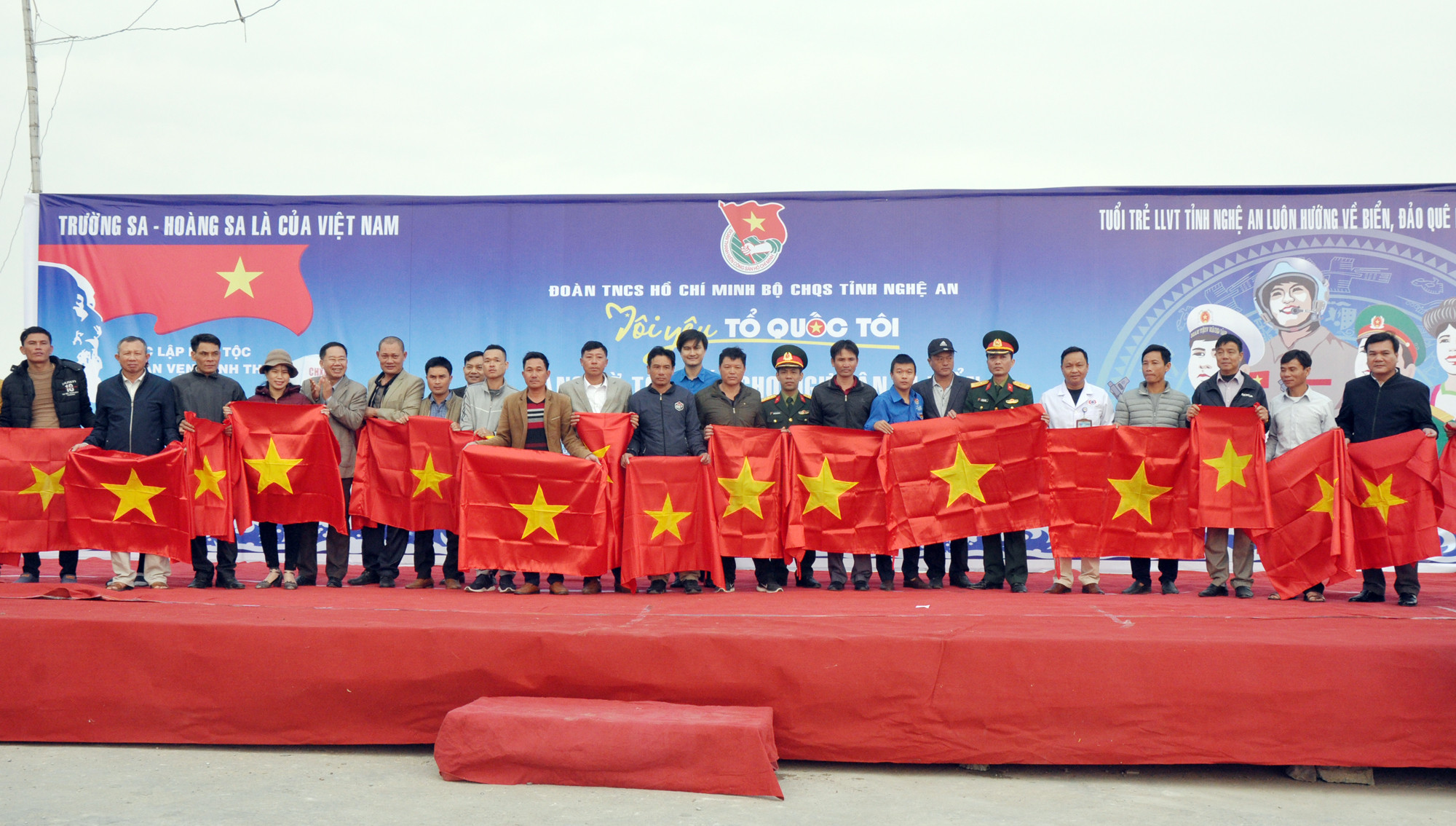Lãnh đạo Bộ Chỉ huy Quân sự tỉnh và huyện Quỳnh Lưu trao cờ Tổ quốc cho đại diện bà con ngư dân các xã ở Quỳnh Lưu.