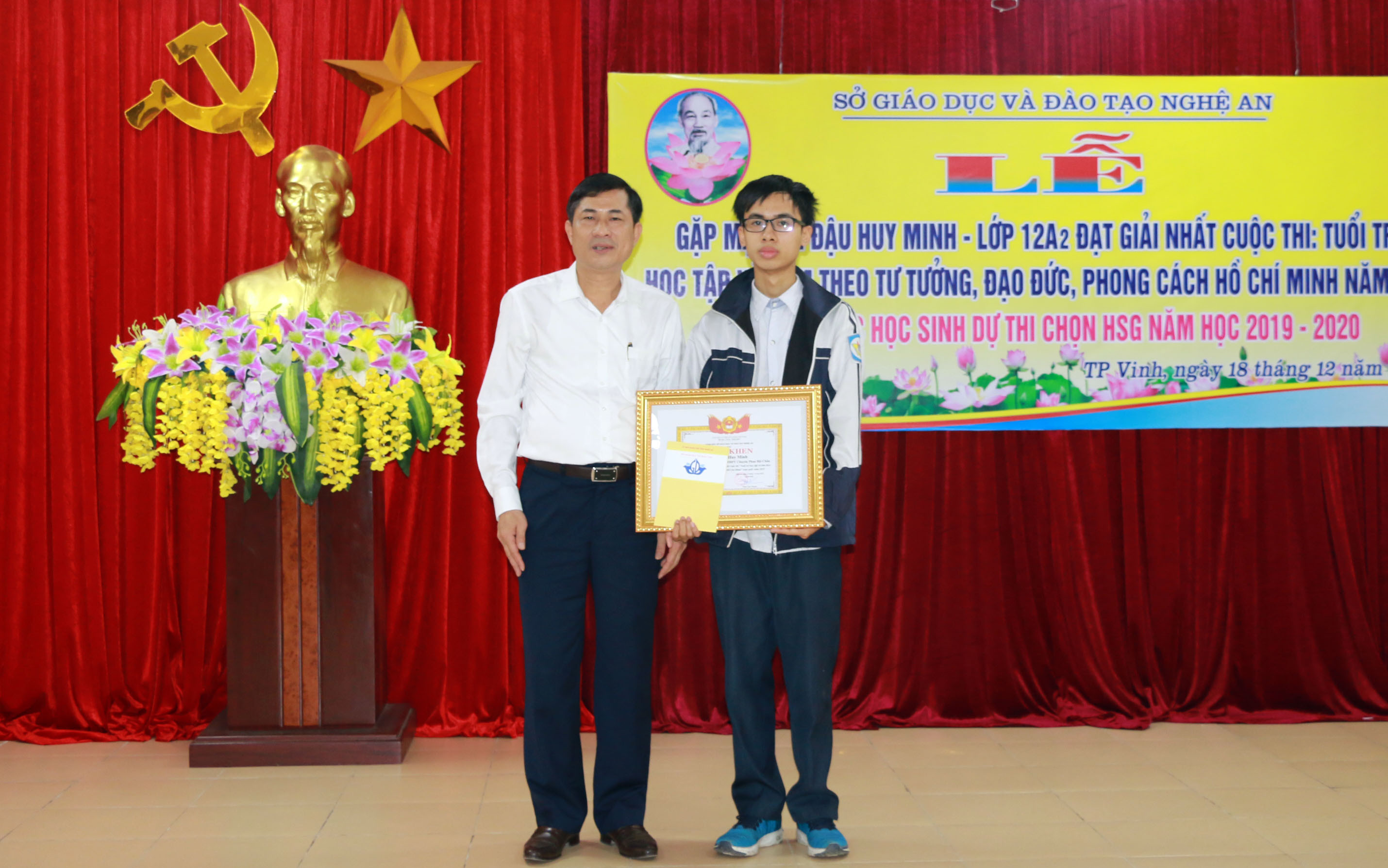 Giám đốc Sở Giáo dục và Đào tạo Thái Văn Thành tặng giấy khen cho em Đậu Huy Minh. Ảnh: Mỹ Hà