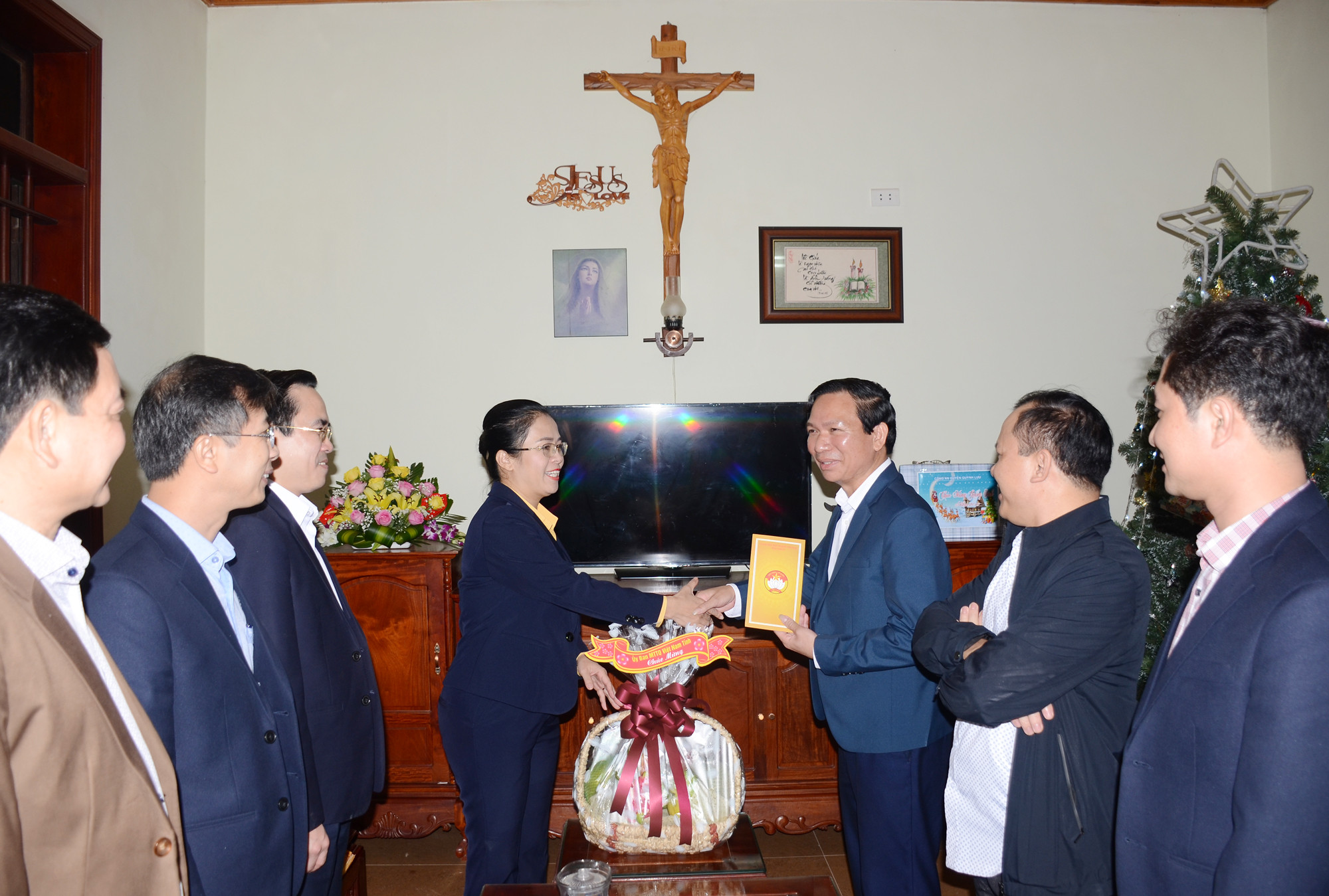 Chủ tịch Ủy ban MTTQ Việt Nam tỉnh Nghệ An tặng hoa, chia sẻ niềm vui giáng sinh với gia đình ông Nguyễn Trung Đức. Ảnh: Thành Chung