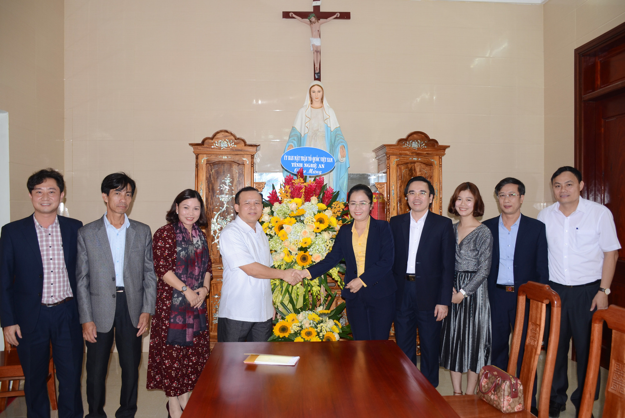 Đồng chí Võ Thị Minh Sinh tặng hoa chúc mừng Giáng sinh tới Linh mục Phan Văn Thắng. Ảnh: Thành Chung