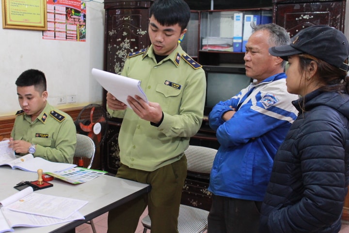 Tài xê Bùi Duy Châu (áo xanh) nghe đọc biên bản vi phạm. Ảnh: Phan Giang