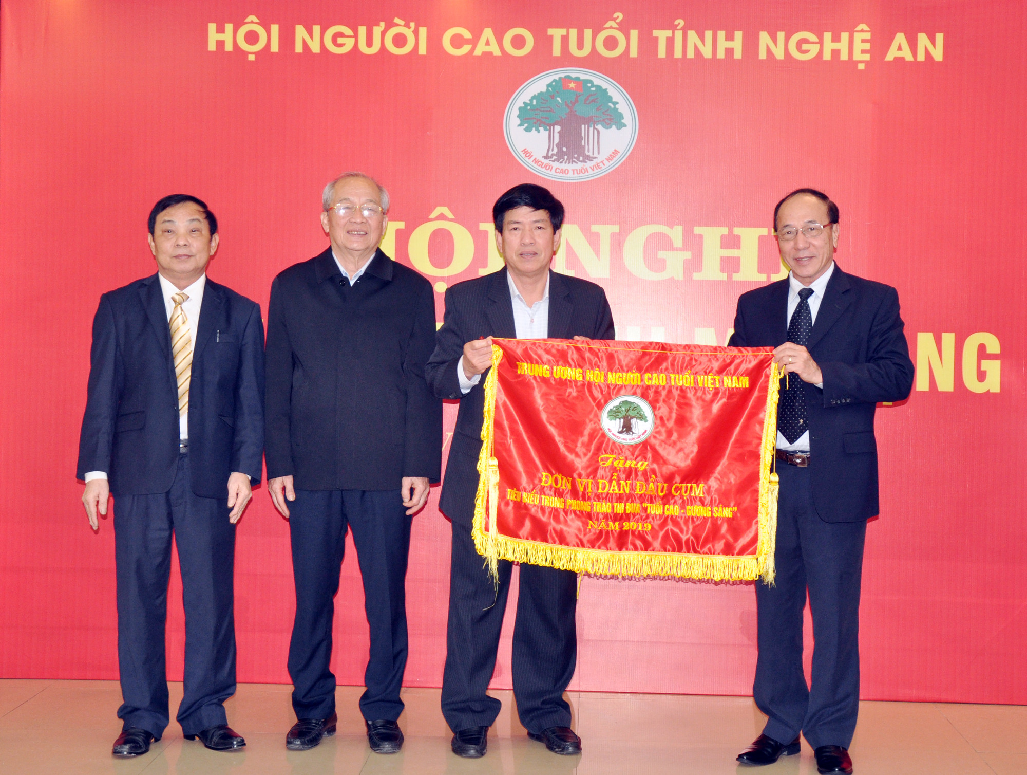 Đồng chí Nguyễn Hòa Bình – Phó Chủ tịch Hội Người cao  tuổi Việt Nam tặng Cờ thi đua cho Hội Người cao tuổi Nghệ An. Ảnh: CK