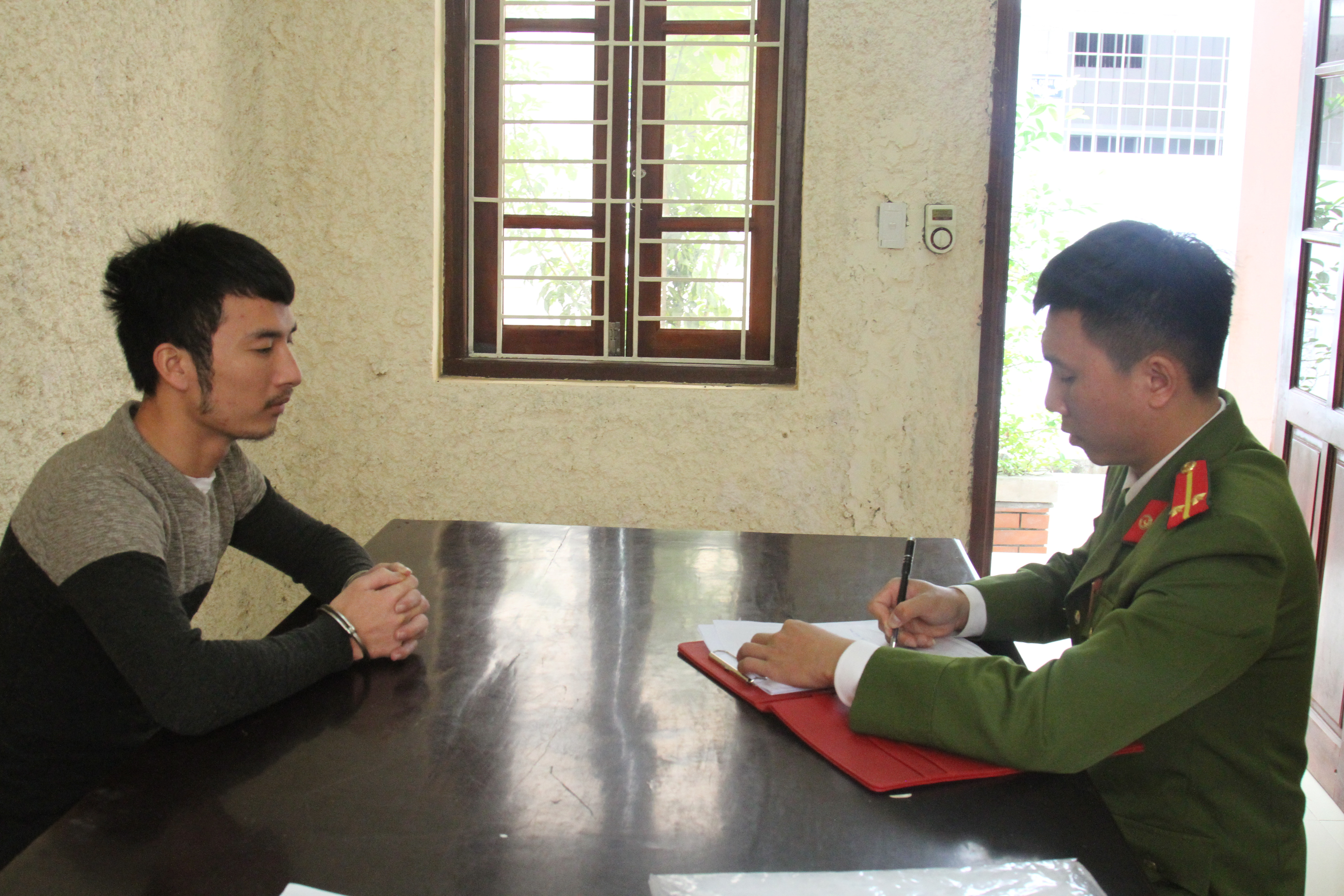 Cán bộ Công an huyện Nam Đàn đang lấy lời khai đối tượng Nguyễn Đức Trình. Ảnh: Bảo Nguyên