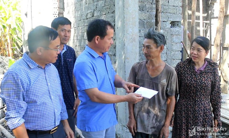 Lãnh đạo huyện Đô Lương trao tiền hỗ trợ 30 triệu đồng làm nhà cho anh Thái Đình Năm, ở xóm Minh Thọ, xã Hòa Sơn. Ảnh tư liệu Hữu Hoàn