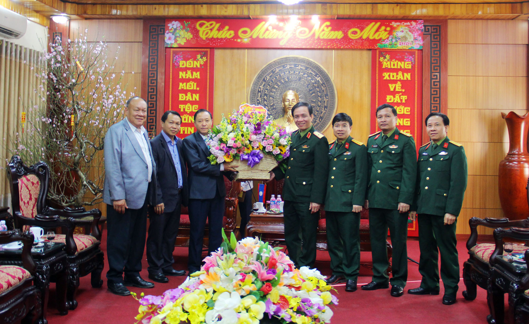 Đoàn công tác tỉnh Xiêng Khoảng trao tặng lẵng hoa tươi thắm và gửi lời chúc mừng năm mới tới các chiến sỹ, cán bộ Quân Khu 4. Ảnh: Thanh Quỳnh