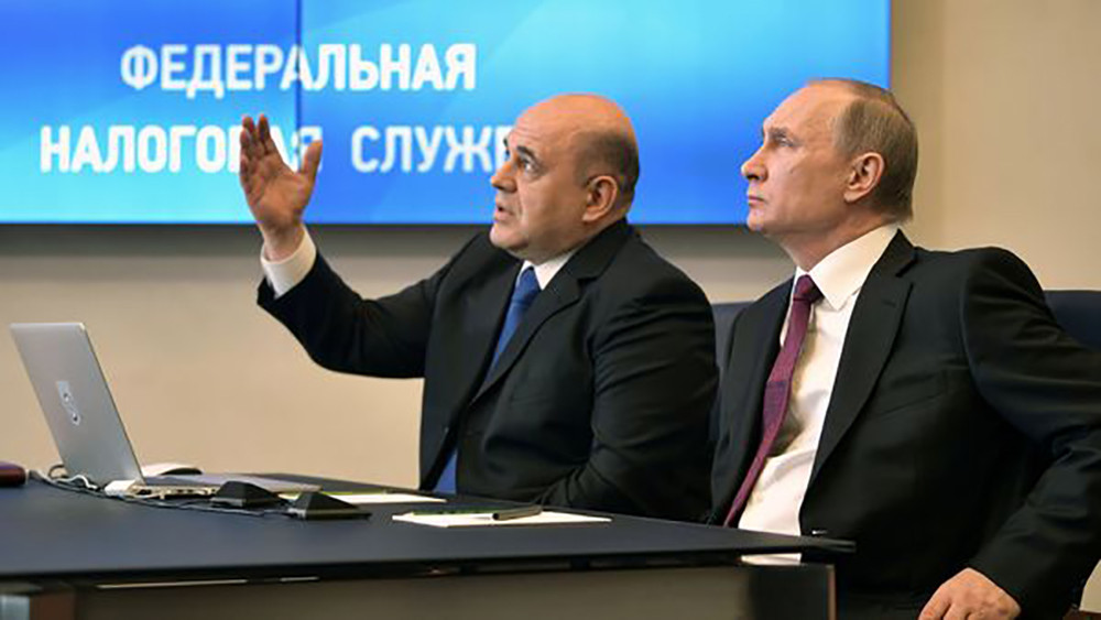 Mikhail Mishustin trong vai trò lãnh đạo Cơ quan Thuế Liên bang Nga và Tổng thống Vlarimir Putin. Ảnh: Reuters