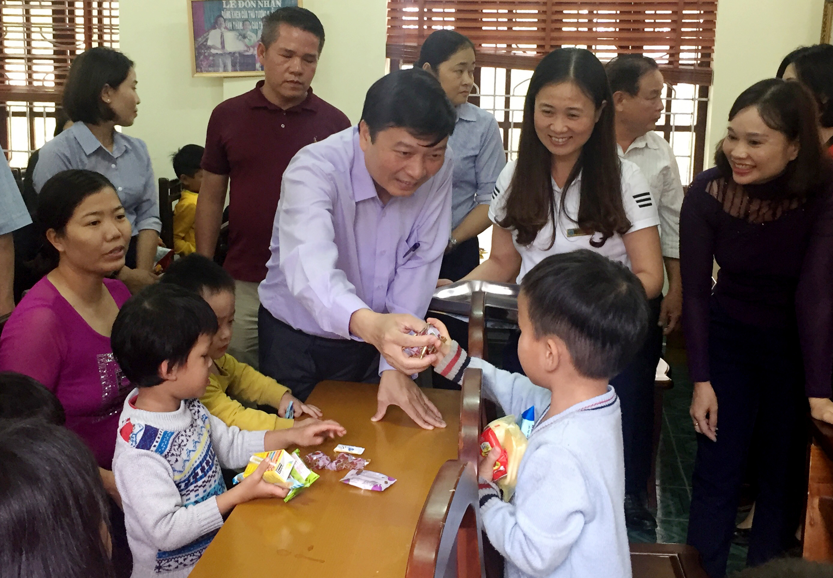 Đồng chí Lê Hồng Vinh trao quà và bánh kẹo cho trẻ em tàn tật, mồ côi tại Trung tâm công tác xã hội Nghệ An. Ảnh: 
