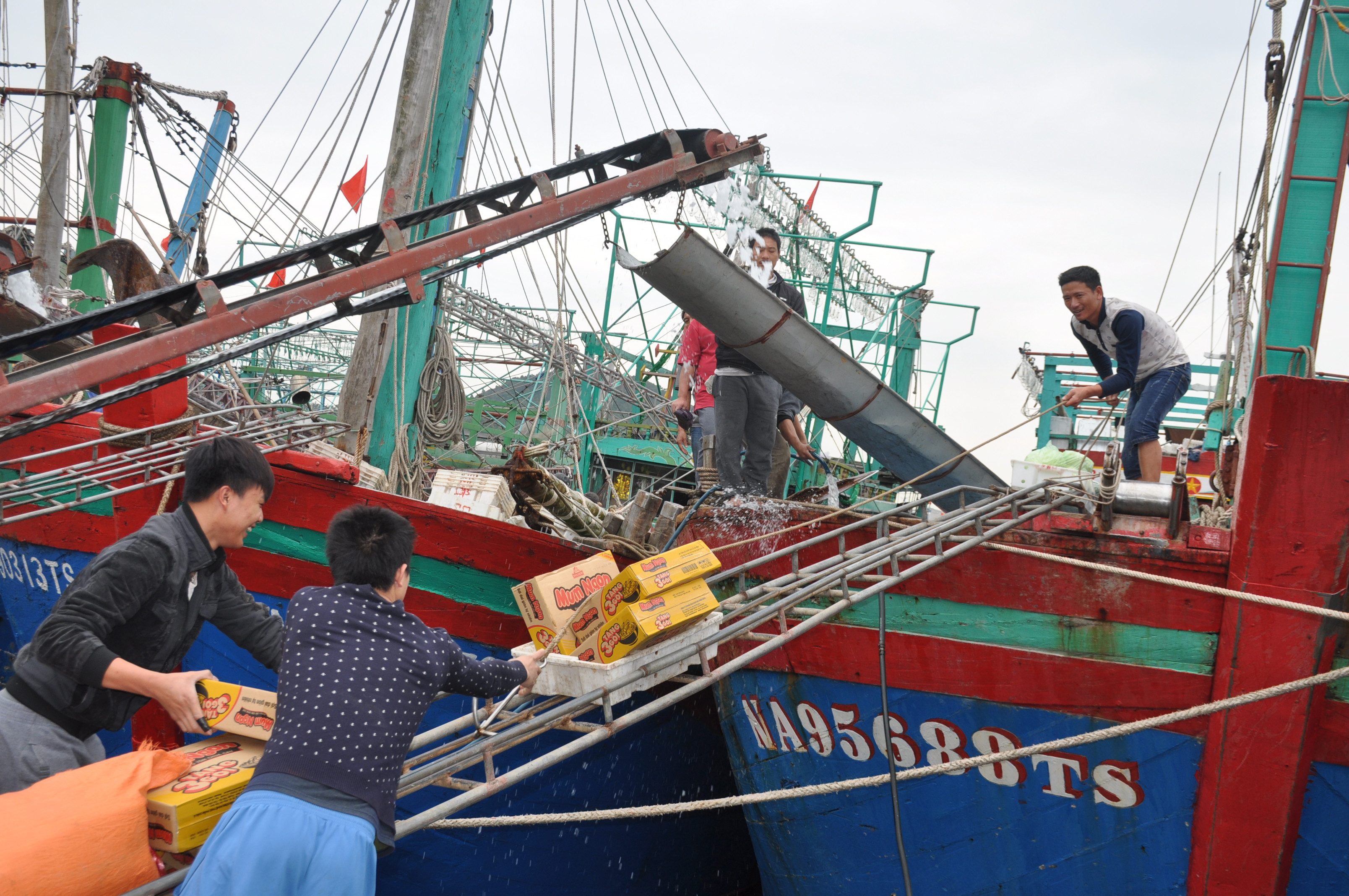 Ngư dân chuẩn bị nhu yếu phẩm cho chuyến vươn khơi đầu năm tại cảng cá Lạch Quèn. Ảnh Việt Phương