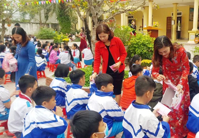 Tặng khẩu trang cho học sinh ở Trường Tiểu học Đông Vĩnh. Ảnh: PV