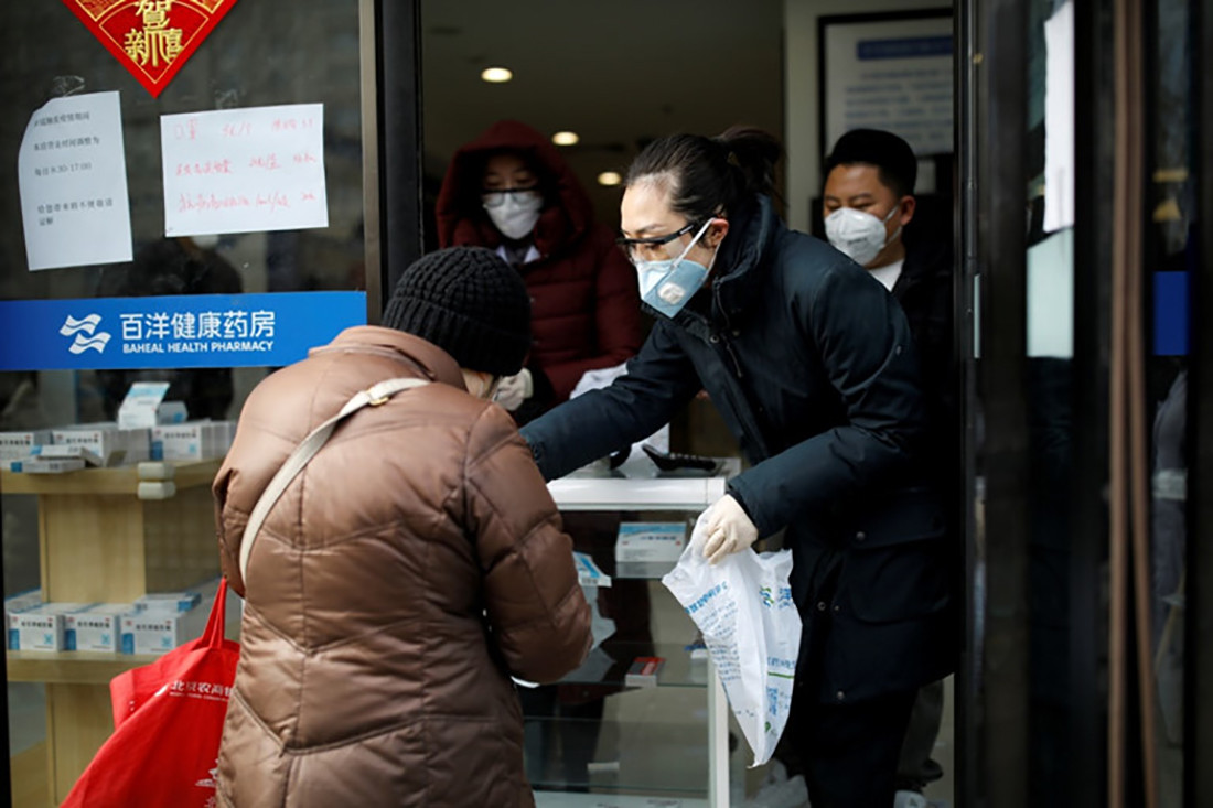 Nhân viên đeo khẩu trang và kính bảo vệ tiếp khách hàng tại hiệu thuốc ở thủ đô Bắc Kinh, Trung Quốc ngày 3/2. Ảnh: Reuters