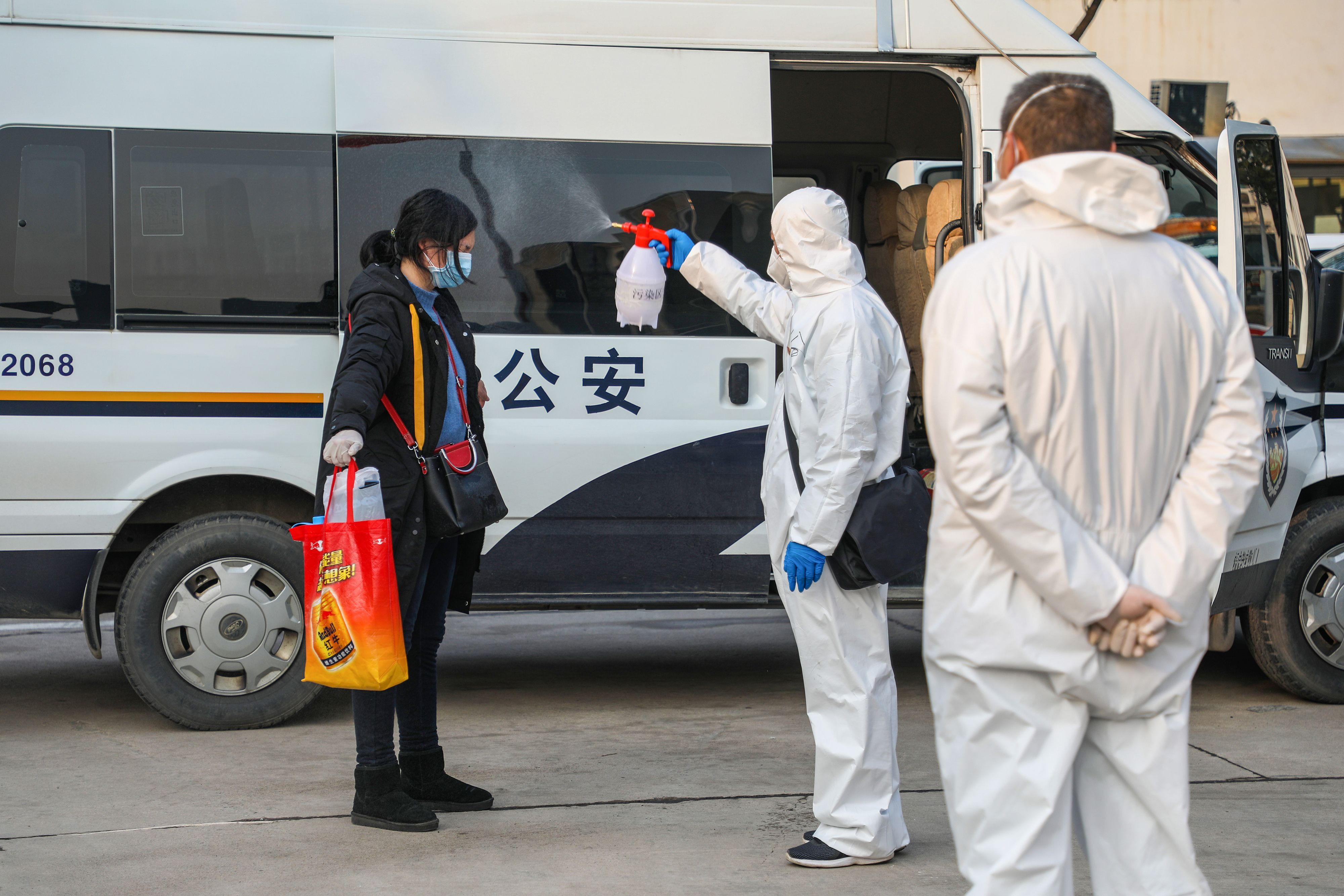 Nhân viên y tế phun thuốc tẩy uế cho bệnh nhân xuất viện trở lại một khu vực cách ly ở Vũ Hán. Ảnh AFP