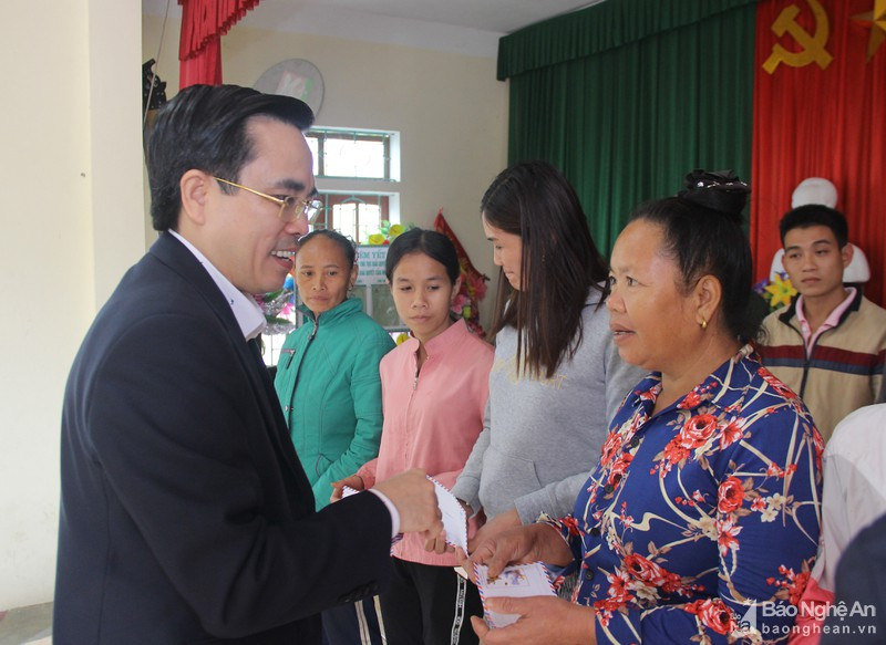 Phó Chủ tịch UBMTTQ tỉnh Lê Văn Ngọc tặng quà cho các hộ nghèo xã Ngoc Lâm. Ảnh: Mai Hoa