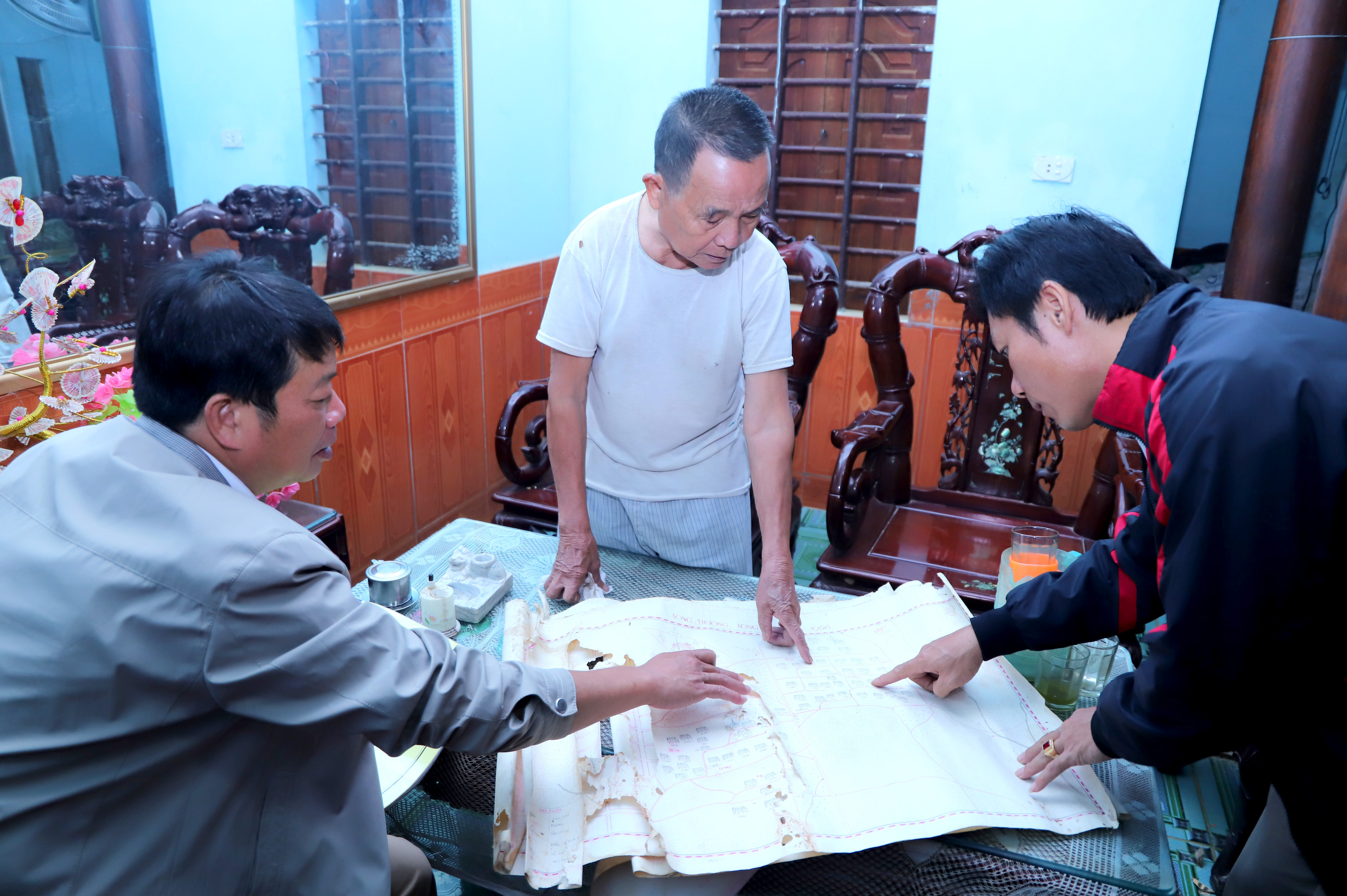 Ông Lê Hùng Lâm (giữa) giới thiệu về bản đồ làng Lung được vẽ cách đây hơn nửa thế kỷ. Ảnh: Thành Duy 
