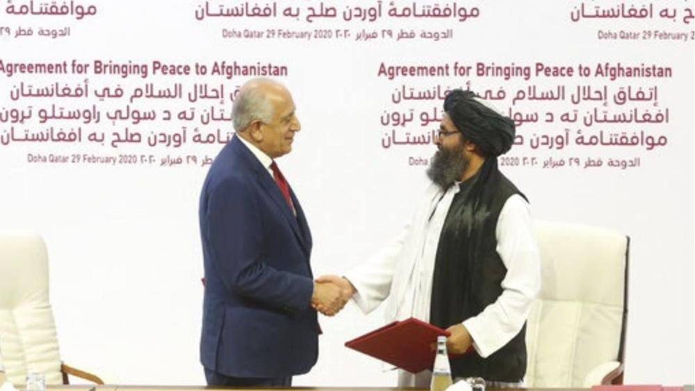 Trưởng phái đoàn Mỹ Zalmay Khalilzad (trái) và ông Mullah Abdul Ghani Baradar, một lãnh đạo Taliban tại lễ ký thỏa thuận ở Doha Qatar hôm 29/2. Ảnh: AP