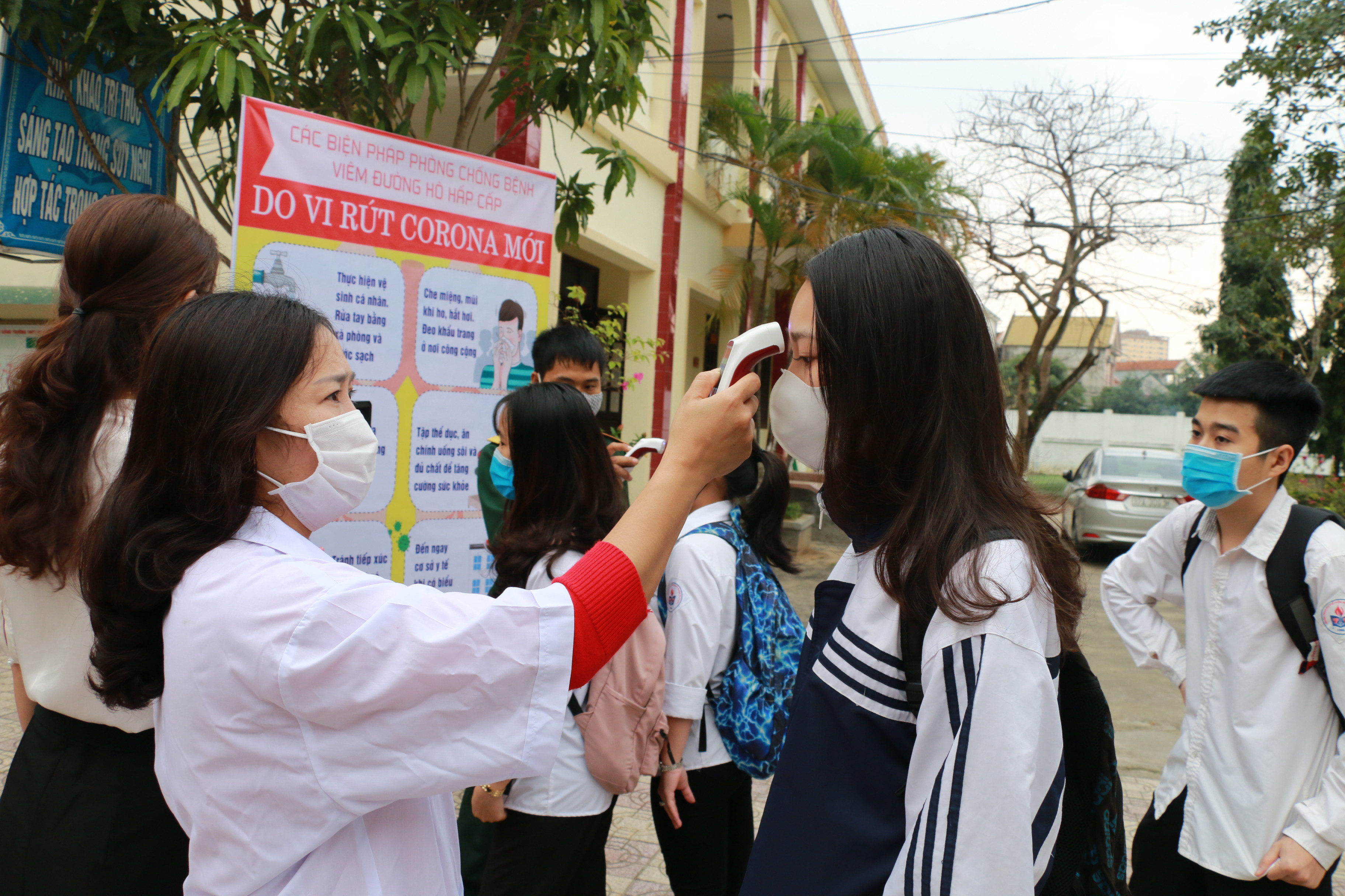 Để phòng ngừa dịch bệnh, Trường THPT Nguyễn Trường Tộ đã đo thân nhiệt cho học sinh ở ngay cổng trường. Ảnh - Mỹ Hà