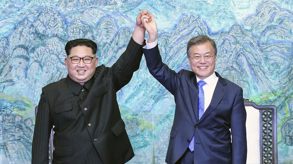 Nhà lãnh đạo Triều Tiên Kim Jong-un (trái) và Tổng thống Hàn Quốc Moon Jae-in giơ cao tay sau khi ký Tuyên bố chung Panmunjom ngày 27/4/2018. Ảnh: AP