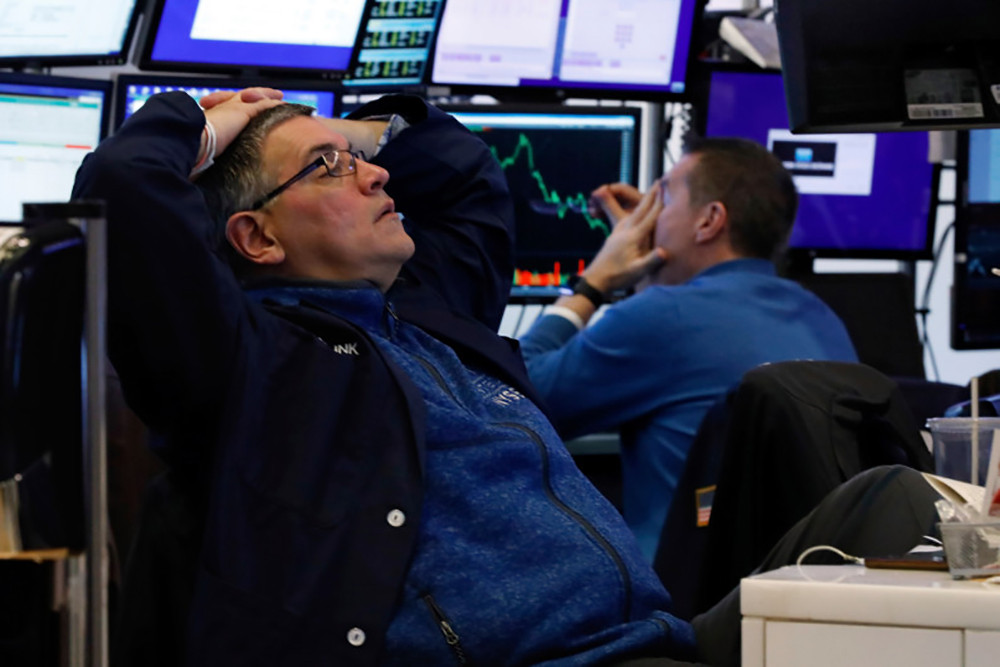 Thất thần khi chứng kiến sự sụt giảm của thị trường chứng khoán New York. Ảnh Reuters