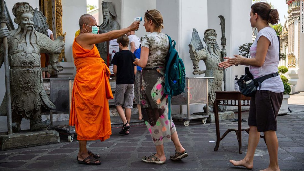 Đo thân nhiệt du khách viếng thăm chùa Wat Pho tại Bangkok, Thái Lan hôm 13/3. Ảnh: Getty