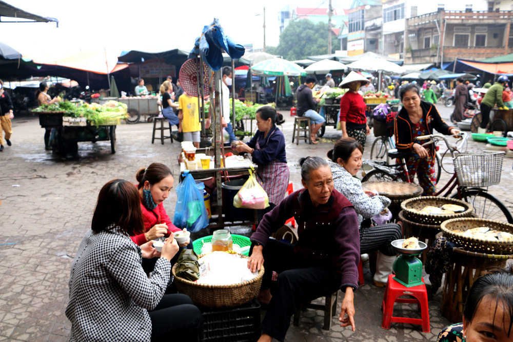 Bà con tiểu thương kinh doanh hàng ăn trước cổng chợ Vinh vẫn vô tư với dịch Viêm phổi cấp. Ảnh: Nguyễn Hải