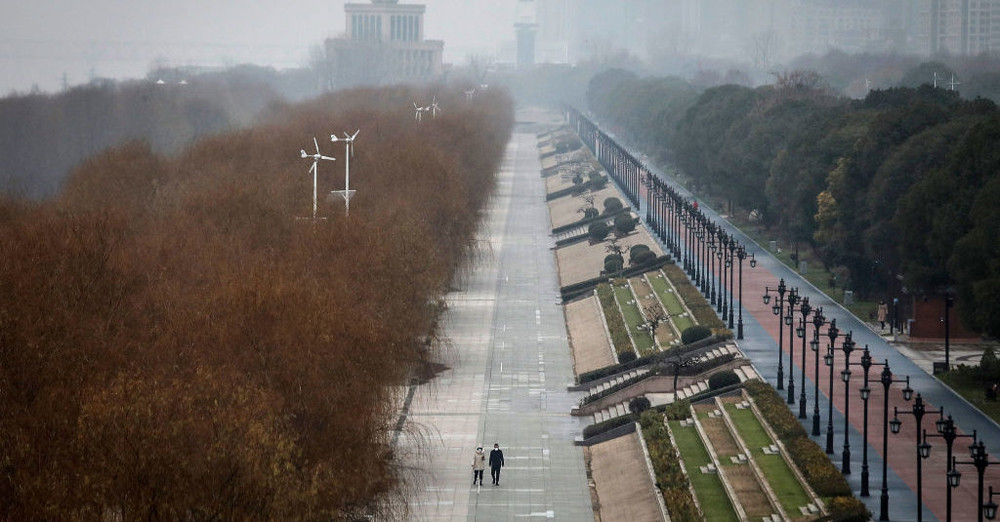 Hai người Vũ Hán đi trên đường phố vắng lặng ngày 27/1/2020. Ảnh Getty Images