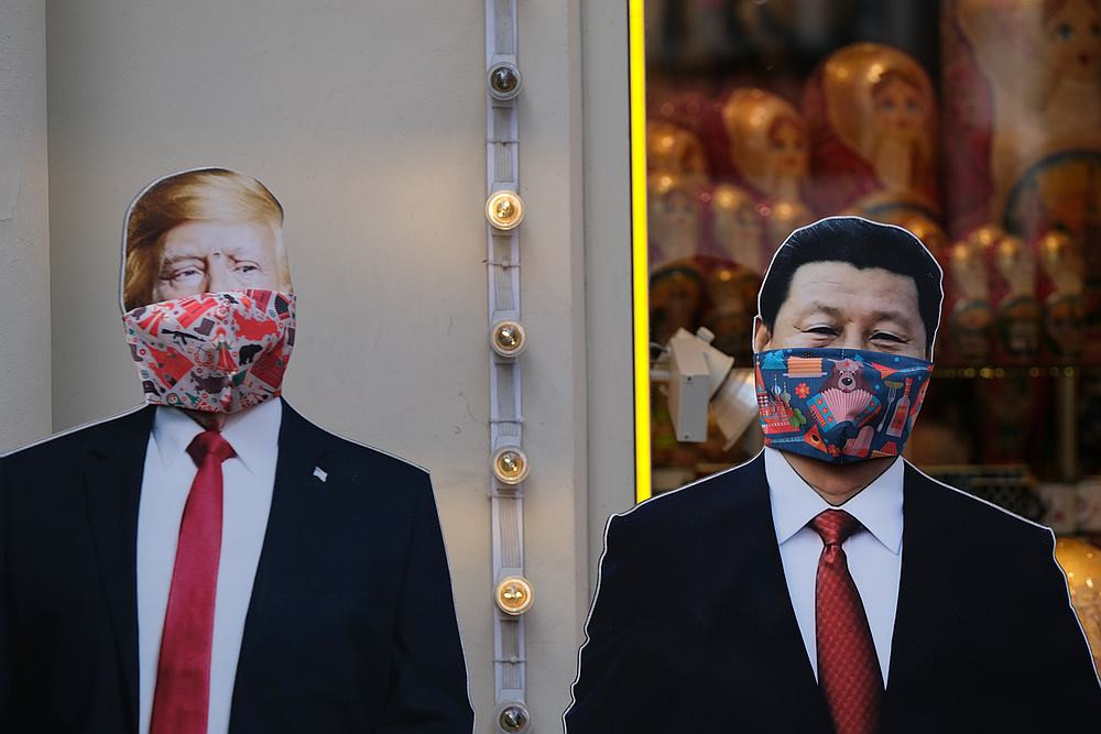 Bìa các tông mô phỏng ông Trump và ông Tập đeo khẩu trang chống Covid-19 được dựng trước một cửa tiệm ở Moskva, Nga. Ảnh: Reuters