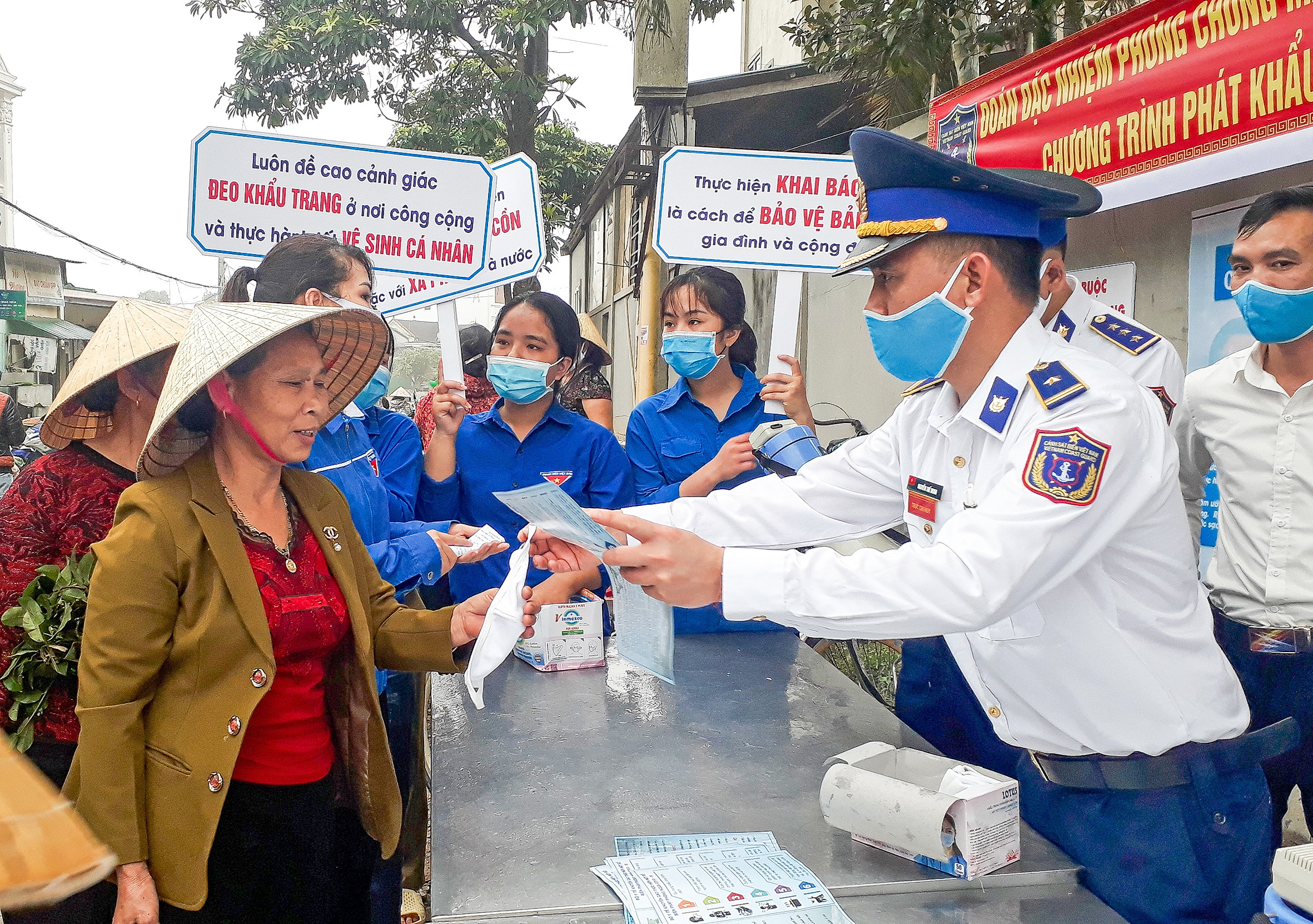 Phát khẩu trang miễn phí cho bà con. Ảnh: An Ngọc