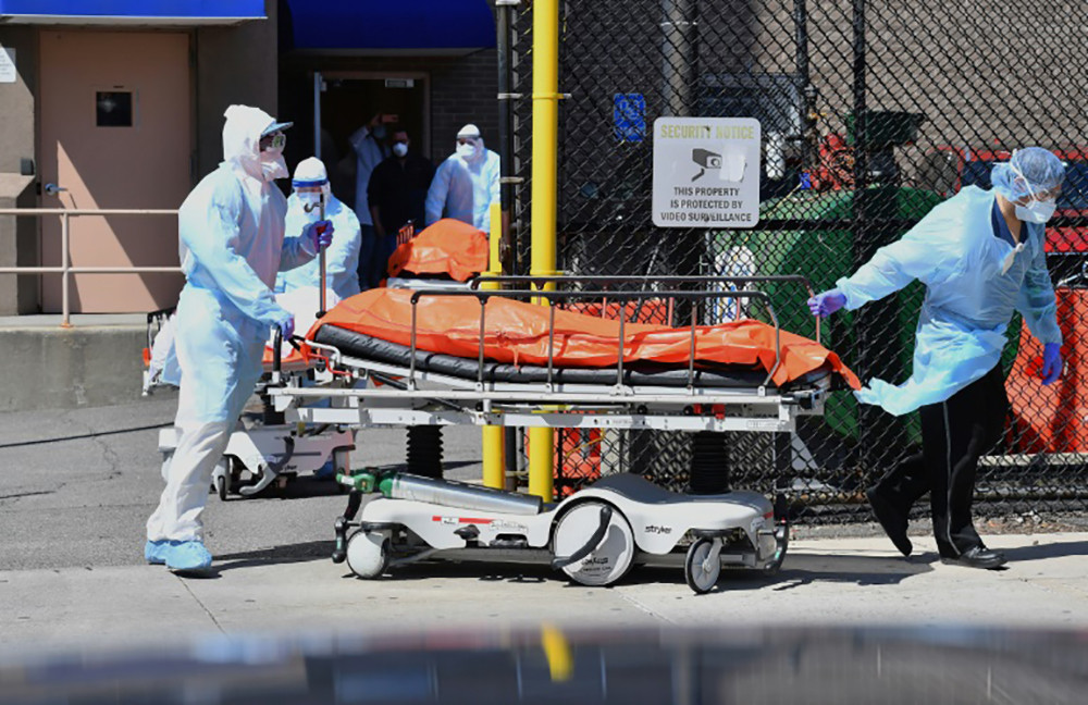 Nhân viên y tế chuyển thi thể bệnh nhân Covid-19 ra xe đông lạnh tại New York. Ảnh: AFP