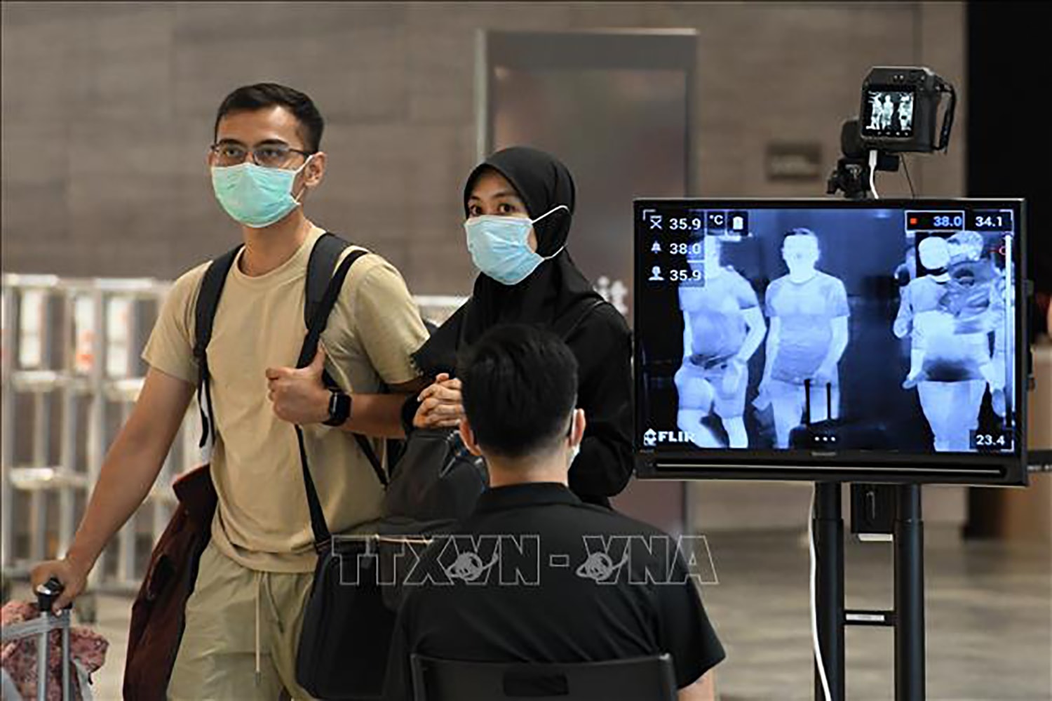 Kiểm tra thân nhiệt phòng lây nhiễm Covid-19 tại sân bay quốc tế Changi, Singapore. Ảnh: TTXVN