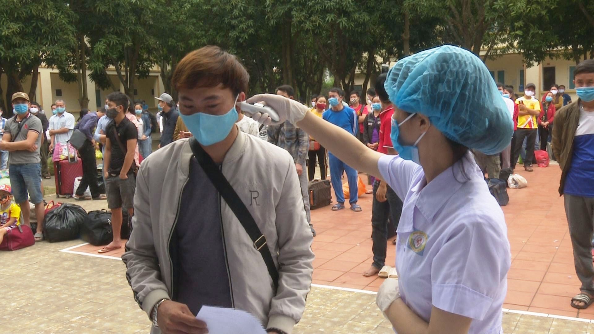 Đo thân nhiệt cho những công dân chuẩn bị được về nhà khi hết hạn cách ly tập trung.
