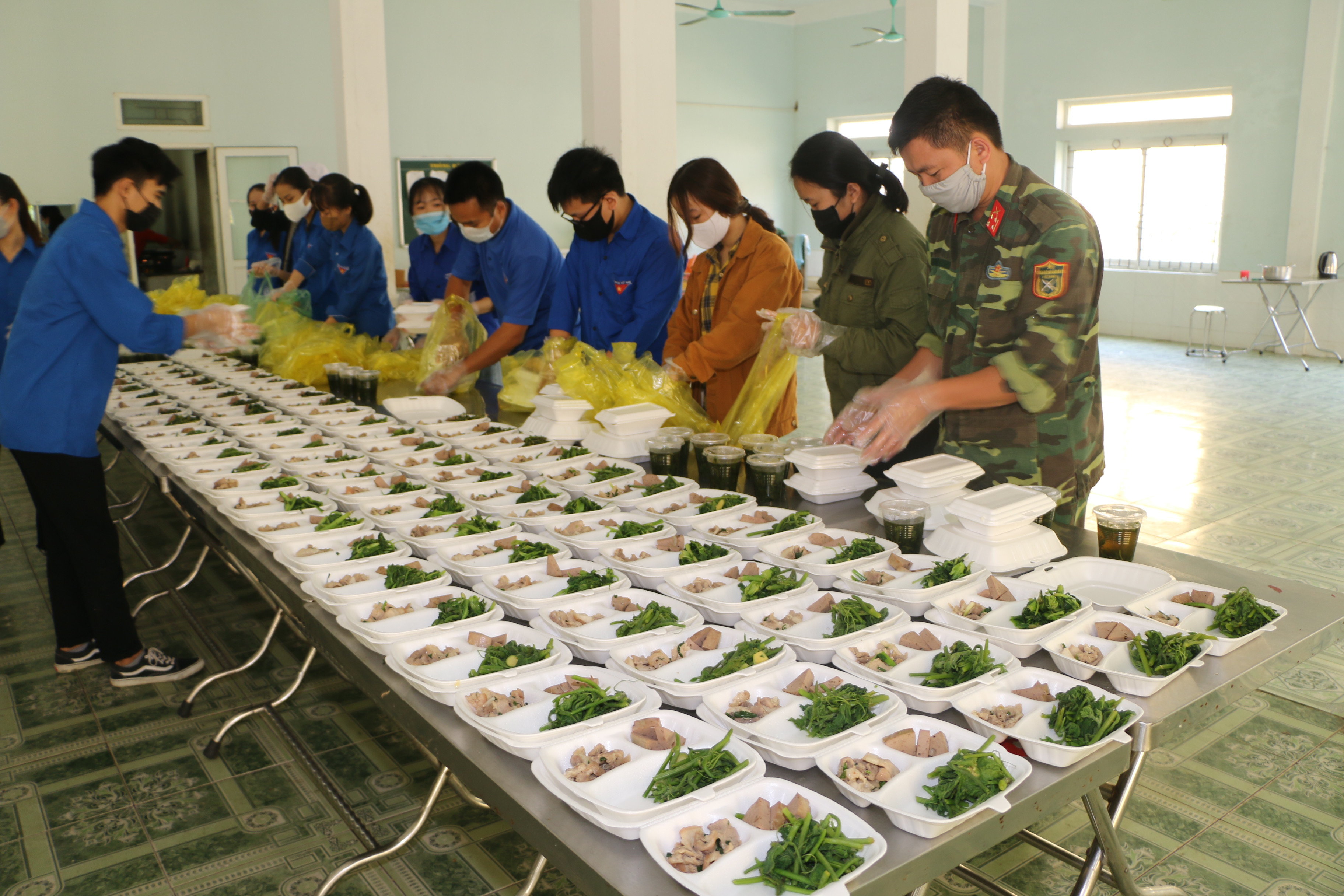 Bên cạnh lực lượng quân đội, có rất nhiều tình nguyện viên đăng ký tham gia phục vụ tại khu bếp của các khu cách ly. Ảnh: Khánh Ly
