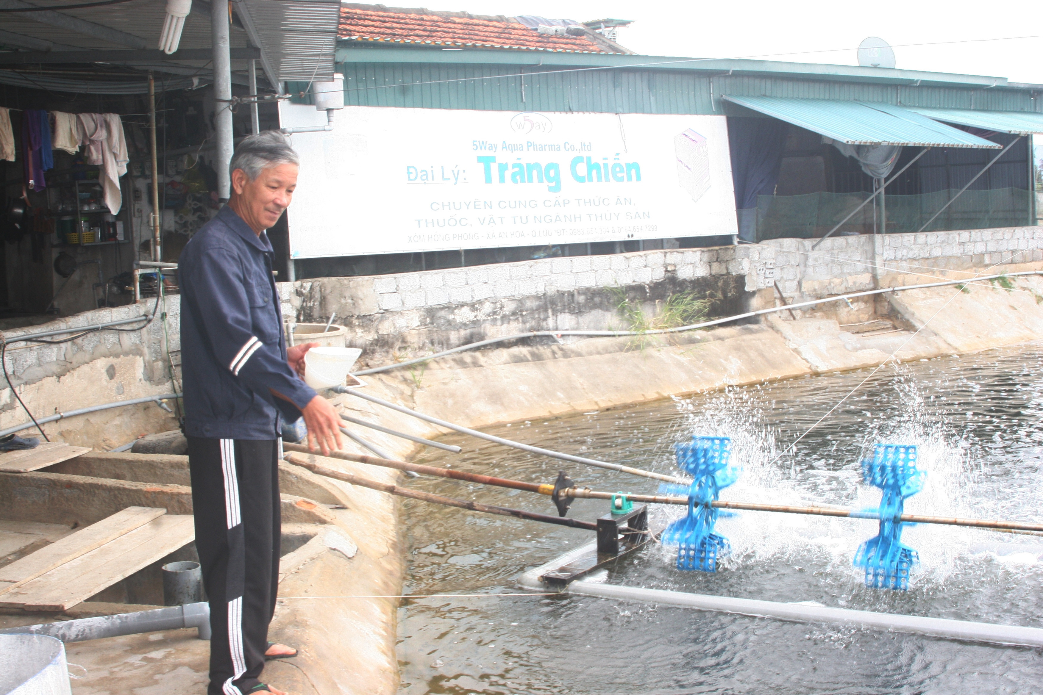 Ông Nguyễn Văn Tráng, hộ nuôi tôm ở xã An Hòa (Quỳnh Lưu) kiểm tra ao, bổ sung thức ăn phòng bệnh cho tôm. Ảnh: Việt Hùng