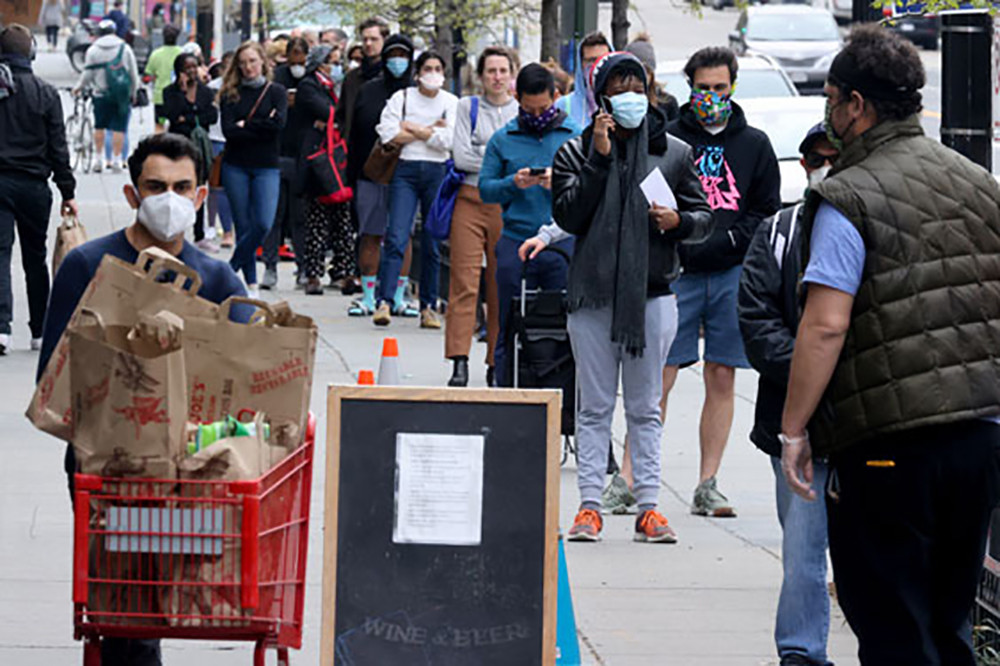 Người dân đeo khẩu trang, xếp hàng chờ mua nhu yếu phẩm tại thủ đô Washington, Mỹ hôm 14/4. Ảnh: Reuters