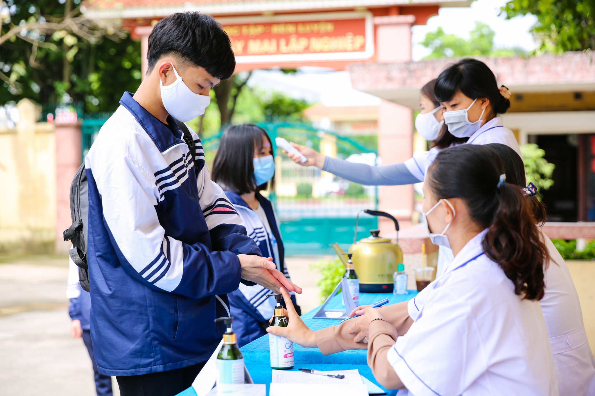 Để đảm bảo an toàn phòng chống dịch covid-19 cho các em học sinh nhà trường đã bố trí cán bộ y tế túc trực để đo thân nhiệt rửa tay sát khuẩn cho các em trước khi vào trường. Ảnh: Đức Anh