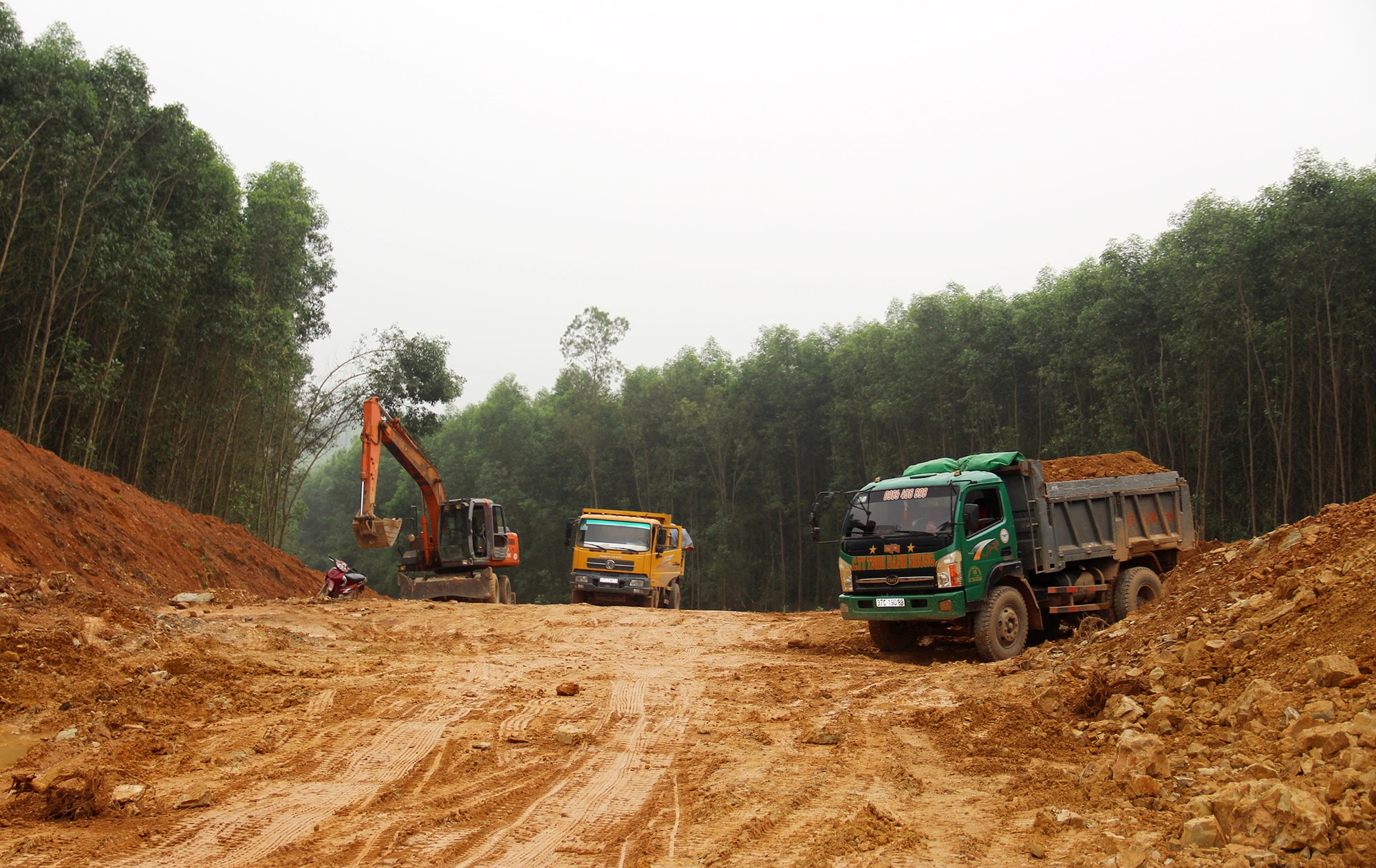 Đơn vị thi công huy động máy móc để hạ độ cao, bạt mái ta luy dốc Truông Gió đoạn giáp ranh xã Nam Thành và Minh Thành (Yên Thành). Ảnh: V.T