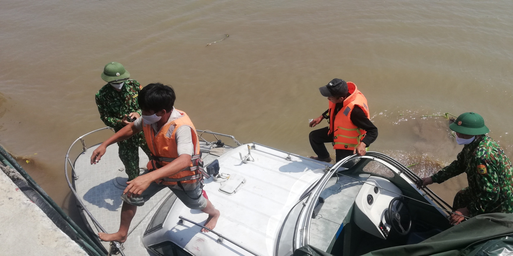 Các ngư dân trên tàu cá gặp nạn được Đồn Biên Phòng Diễn Thành dùng ca nô đưa về Trạm kiểm soát Lạch Vạn. Ảnh: Mai Giang