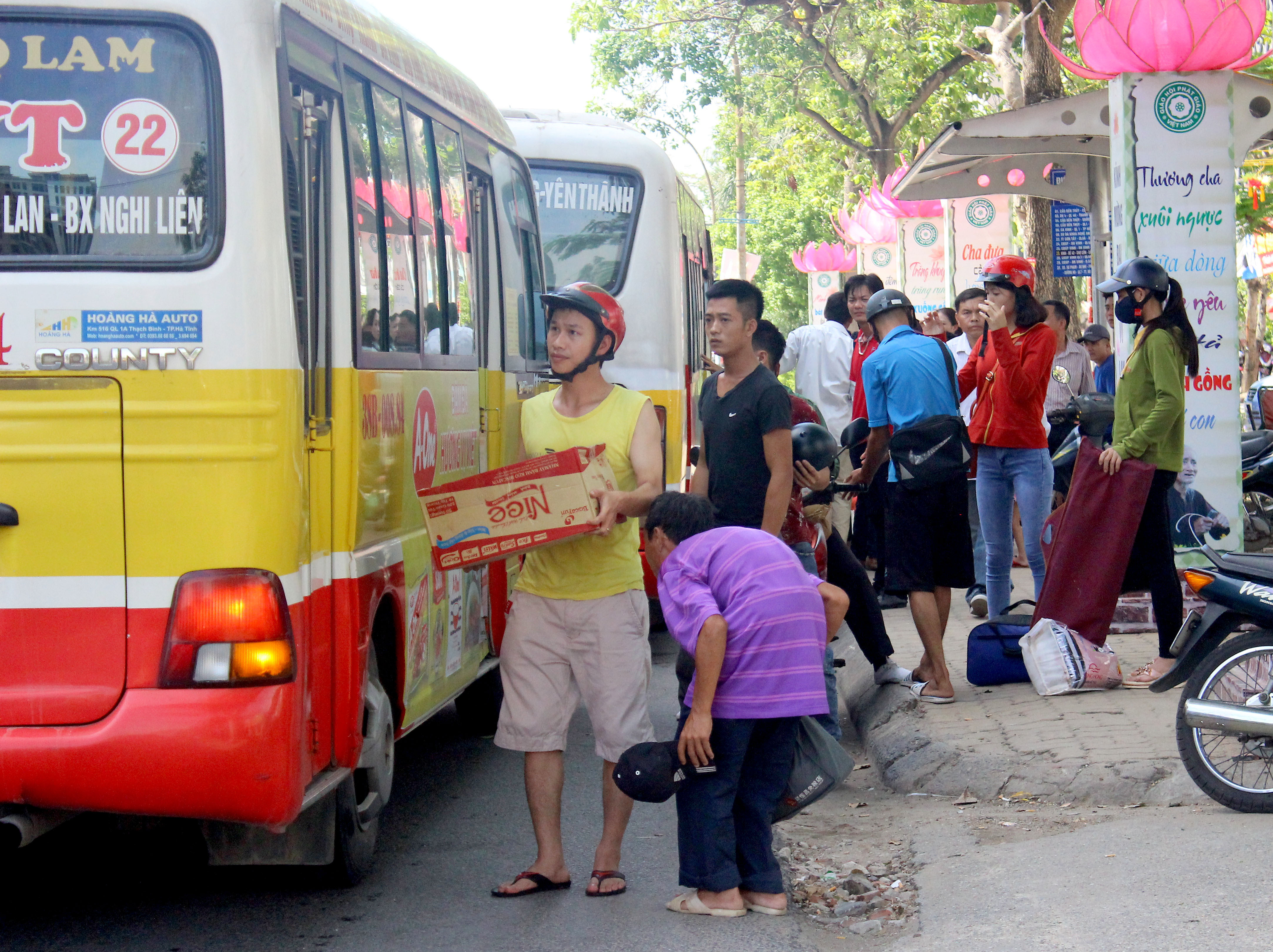 Hành khách đón xe bus trên đường Mai Hắc Đế. Ảnh: Quang An