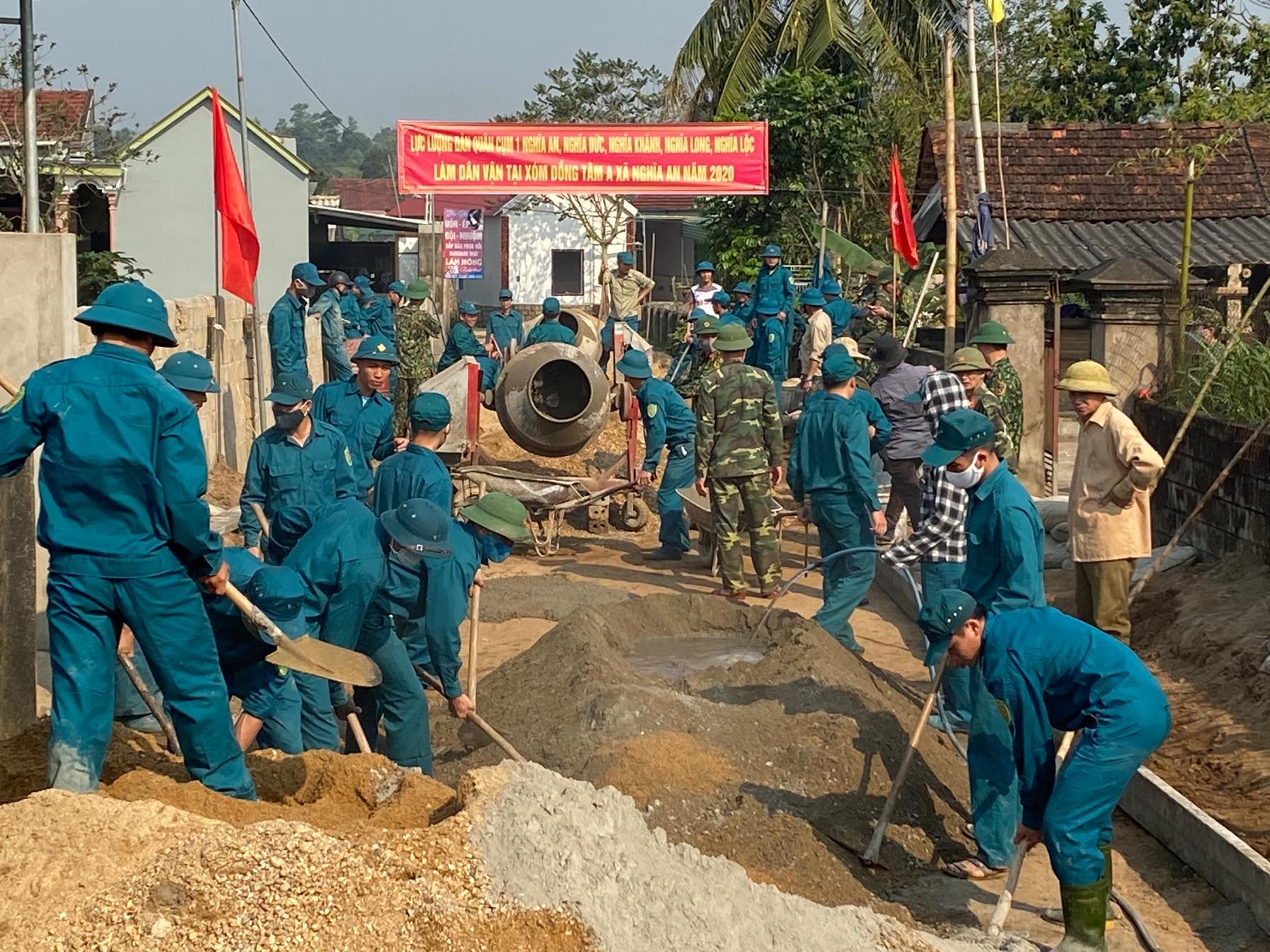 Cán bộ, chiến sỹ Ban CHQS huyện Nghĩa Đàn cùng dân quân tự vệ hỗ trợ ngày công lao động làm đường bê tông liên xóm. Ảnh: Minh Thái