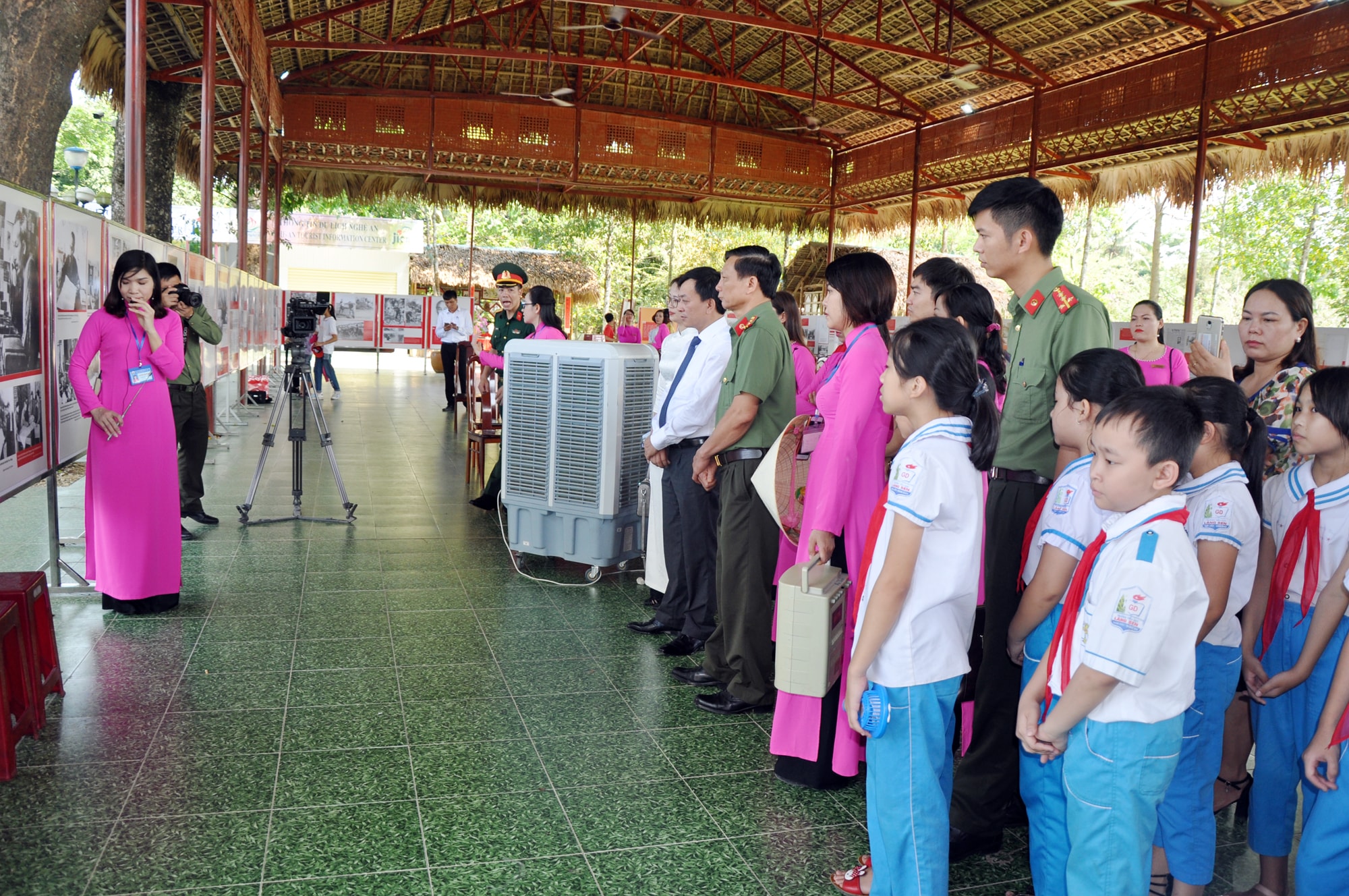 Cán bộ, chiến sỹ lực lượng vũ trang và các em học sinh nghe thuyết minh về triển lãm. Ảnh: Công Kiên