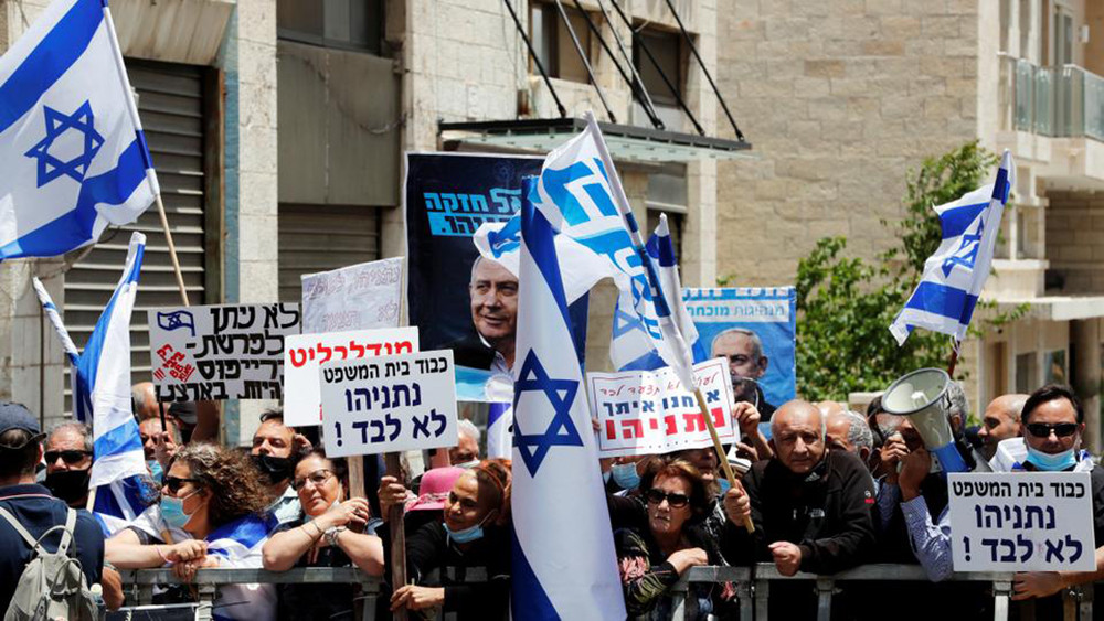Những người ủng hộ Thủ tướng Israel Benjamin Netanyahu vẫy cờ và bảng hiệu ngay trước khi phiên tòa xét xử ông Netanyahu bắt đầu. Ảnh: Reuters