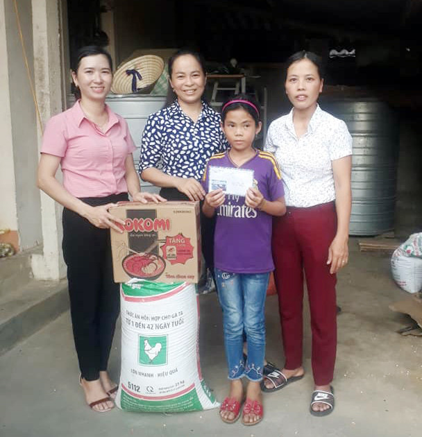 Cán bộ Hội Liên hiệp Phụ nữ xã Đức Sơn (Anh Sơn) trao tặng gạo, mì tôm và tiền cho Lục Thị Phượng. Ảnh: Tường Anh