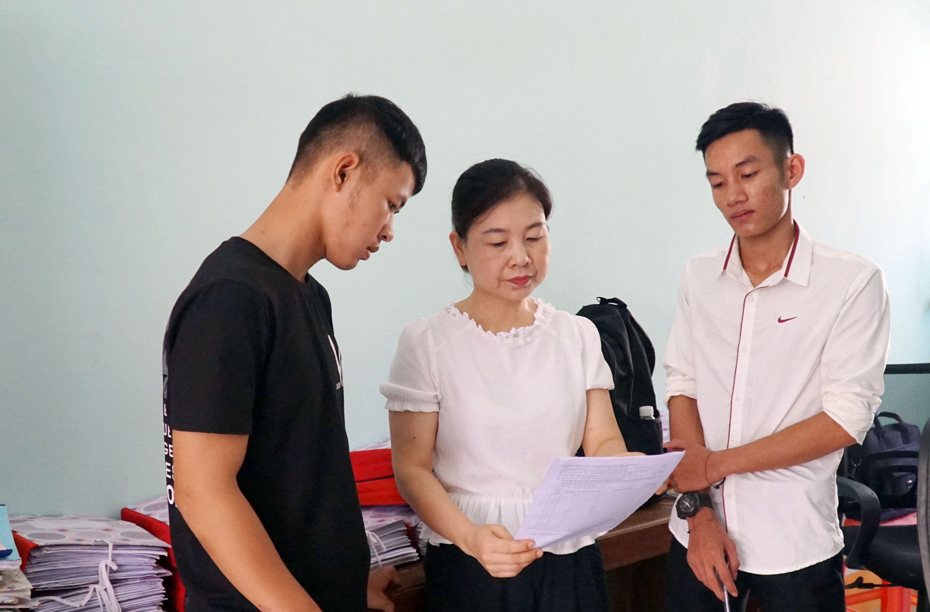 Giáo viên Trường THPT Quỳ Châu hướng dẫn thí sinh tự do đăng ký hồ sơ tuyển sinh. Ảnh: Mỹ Hà
