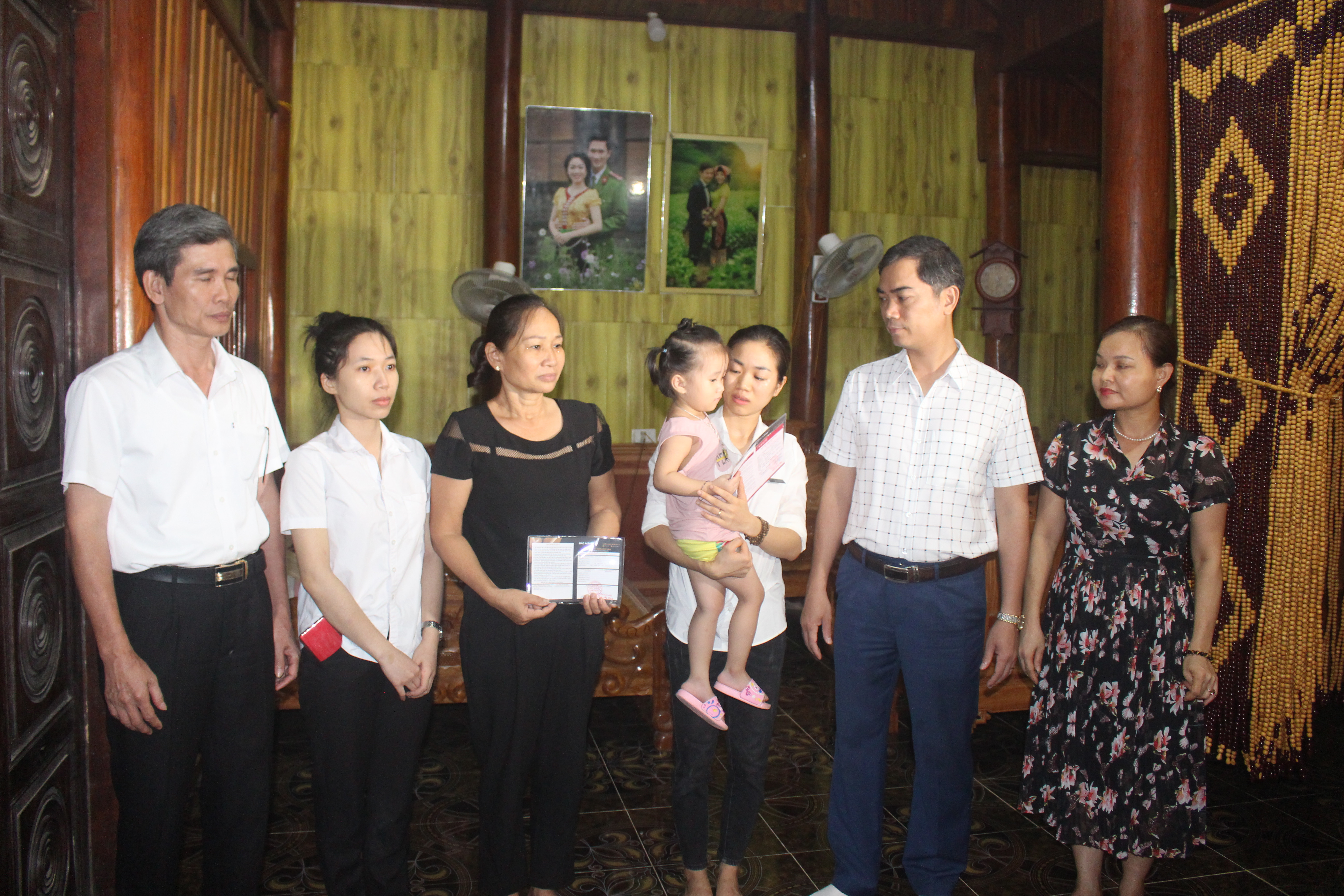 Đoàn công tác trao tặng 3 sổ tiết kiệm cho gia đình đại úy Sầm Quốc Nghĩa.