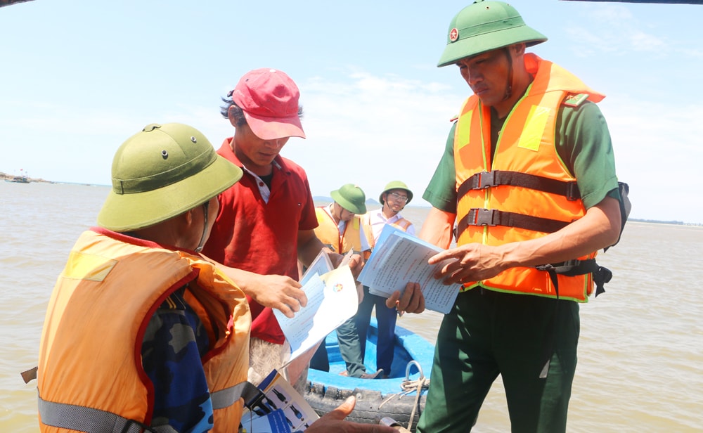 Kiểm tra và phát tờ rơi tuyên truyền cho bà con ngư dân đánh bắt khai thác đúng vùng biển quy định. Ảnh: Nguyễn Hải