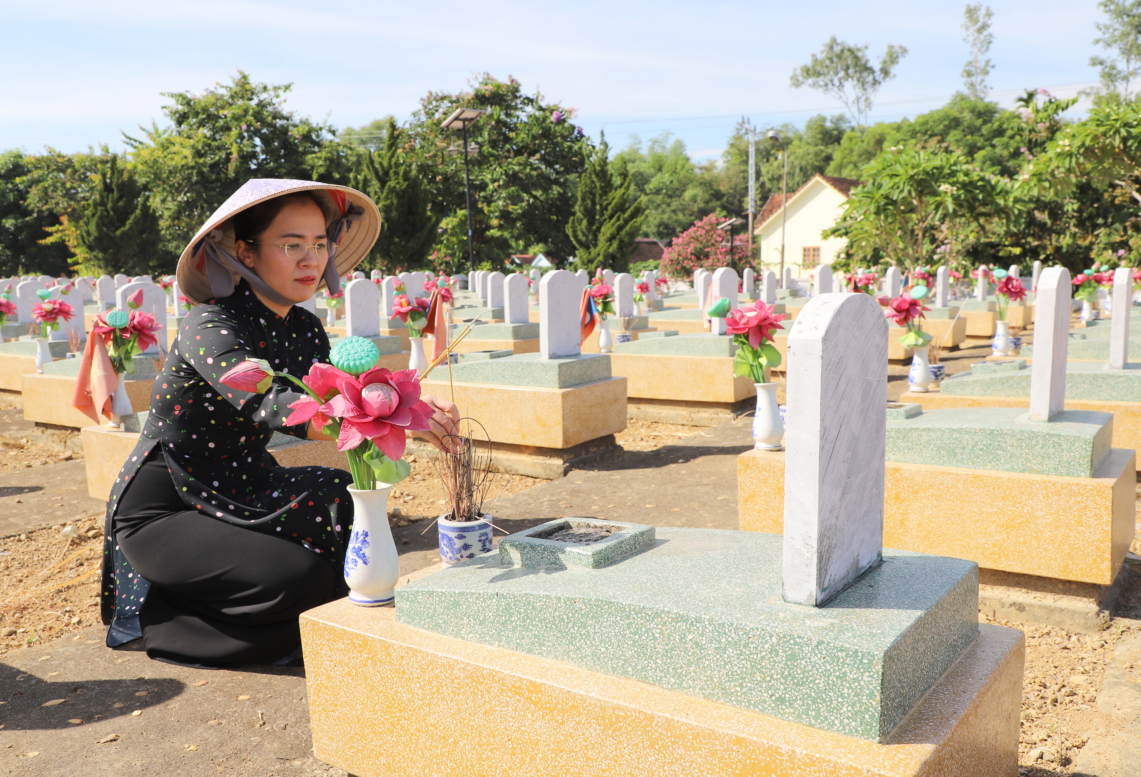 Đồng chí Võ Thị Minh Sinh - Chủ tịch Ủy ban MTTQ tỉnh thắp hương tại phần mộ các liệt sĩ. Ảnh: Phạm Bằng