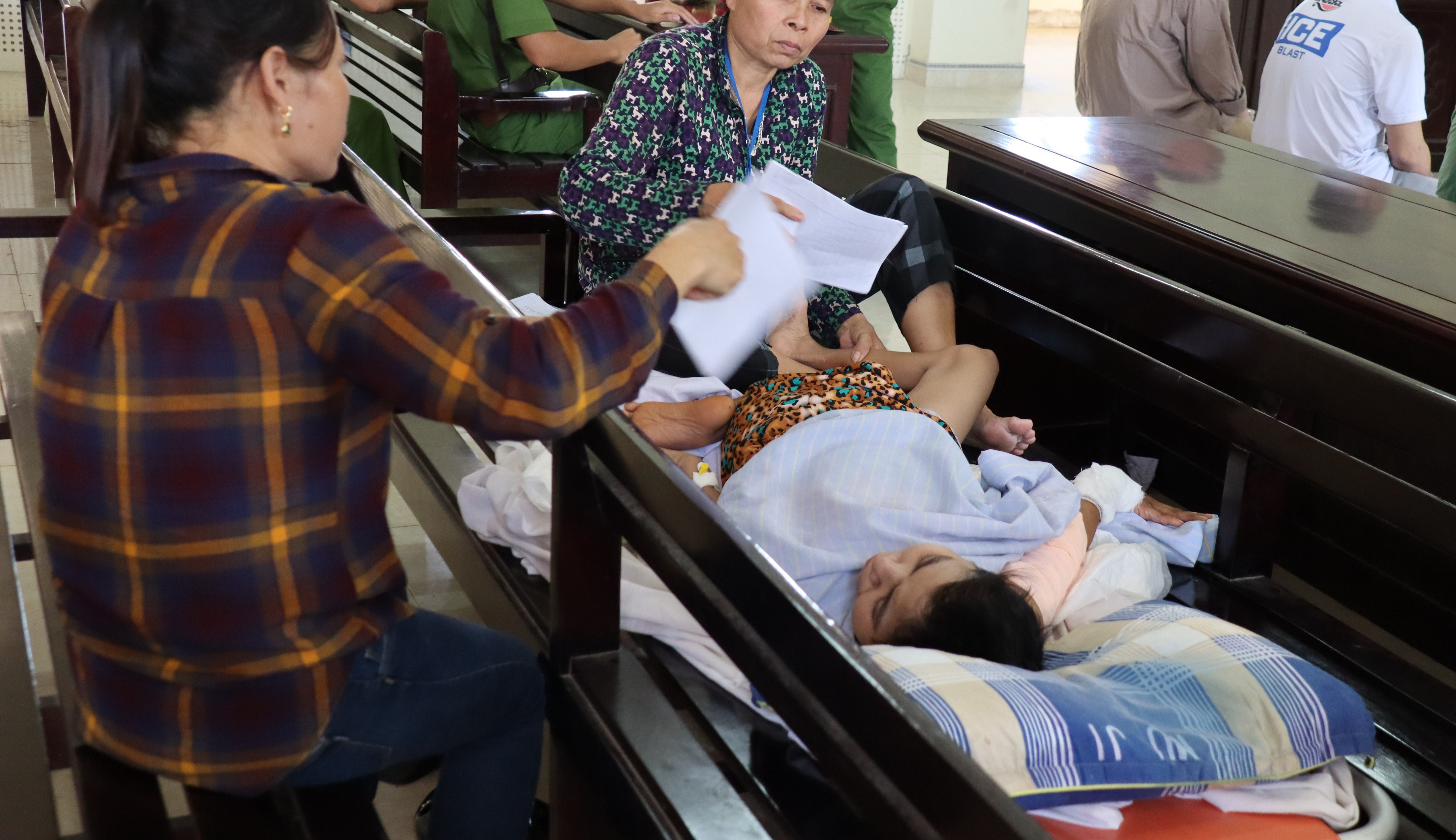 Chị Nguyễn Thị Q. phải nằm trên xe đẩy trong phiên xử phúc thẩm vì sức khỏe quá yếu.