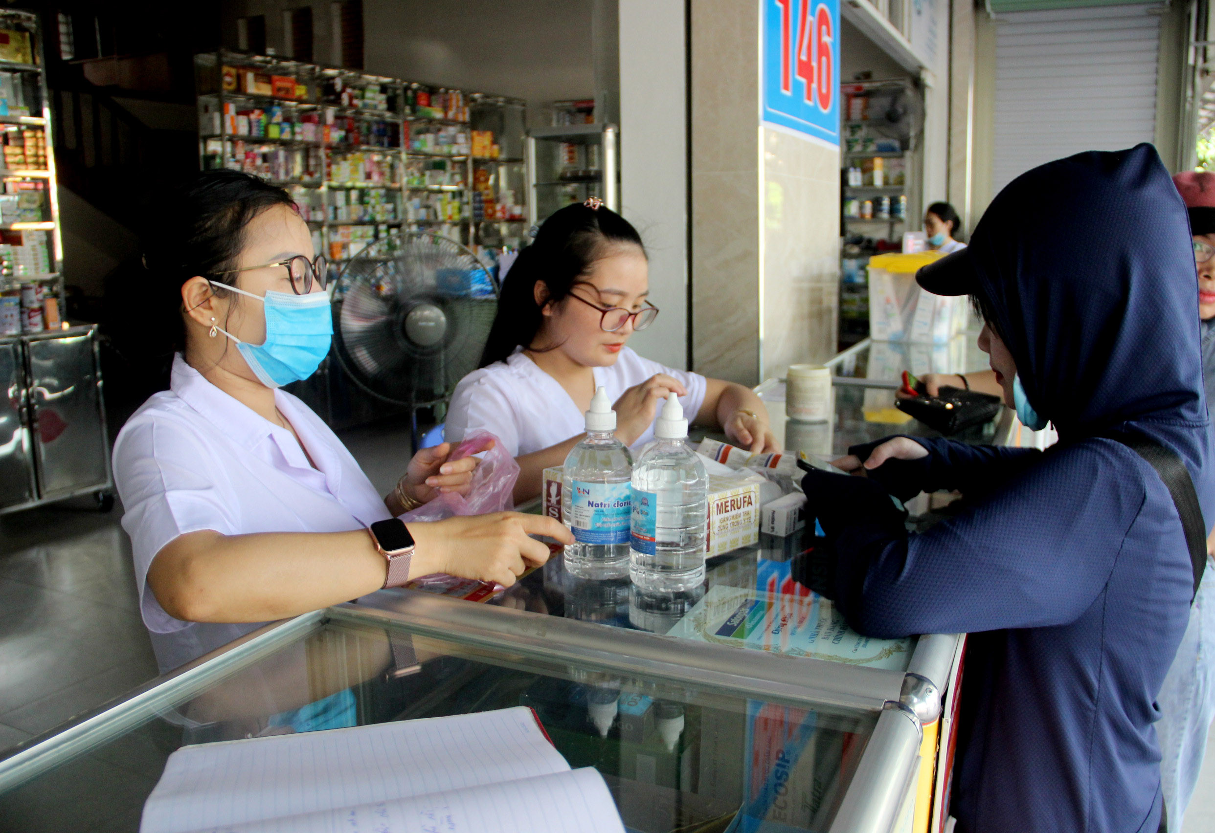 Người dân tìm mua nước sát khuẩn, khẩu trang y tế tại một hiệu thuốc trên địa bàn TP.Vinh sáng 27/7. Ảnh: Quang An